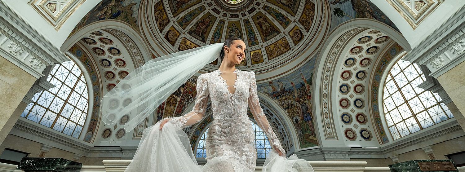Bride under Capitol dome with dramatic veil aerial view Puerto Rico — professional wedding cinematographer Raymond Vega
