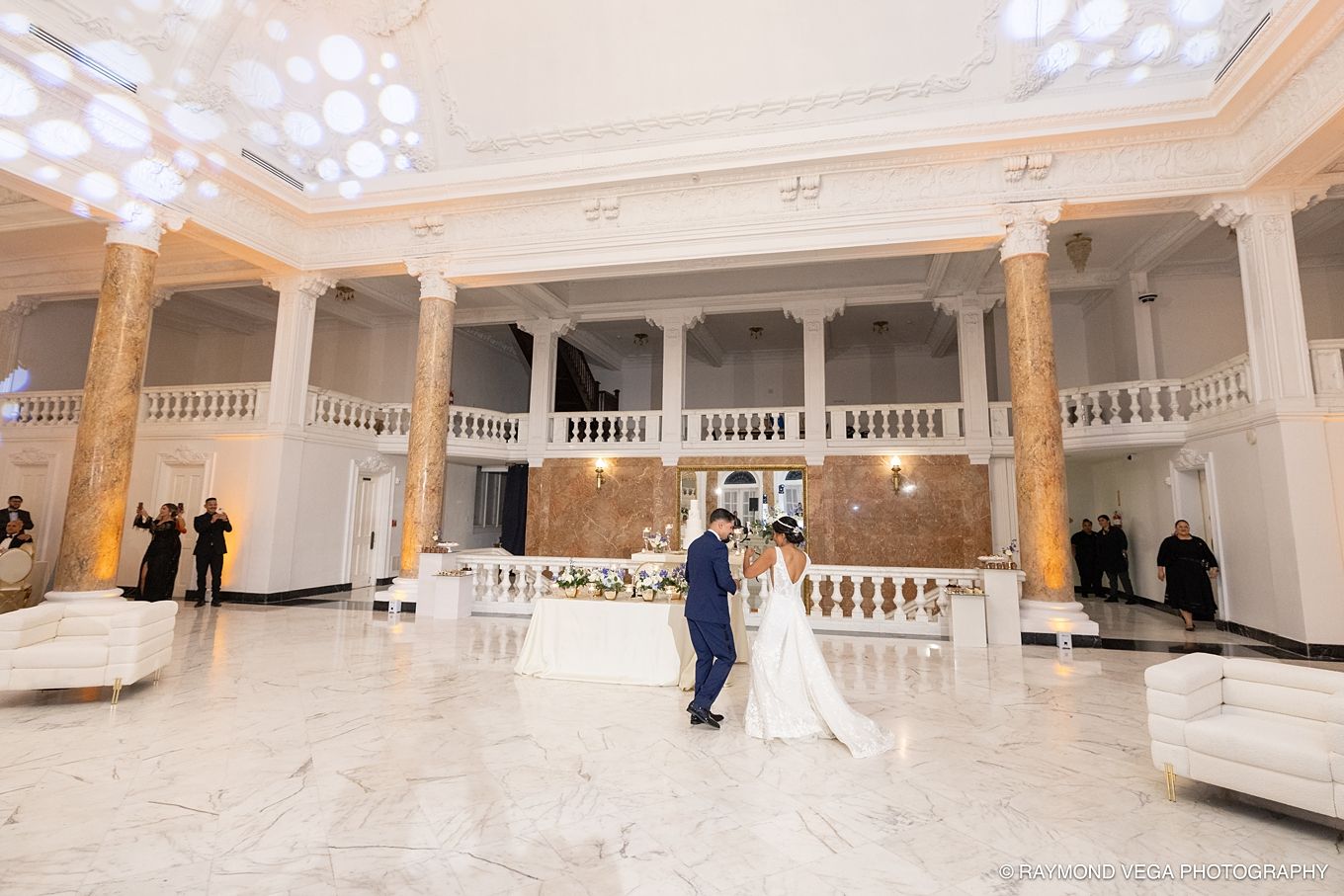 Elegant wedding couple shares first dance in grand ballroom with marble floors and ornate white balconies. Antiguo Casino Puerto Rico wed