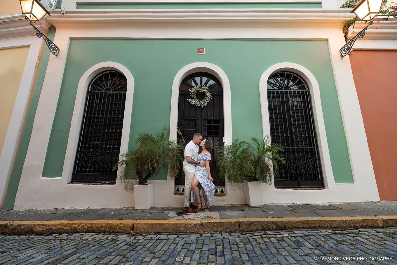 Couple embracing in front of colorful colonial building on cobblestone street in Old San Juan, Puerto Rico. - Love Story