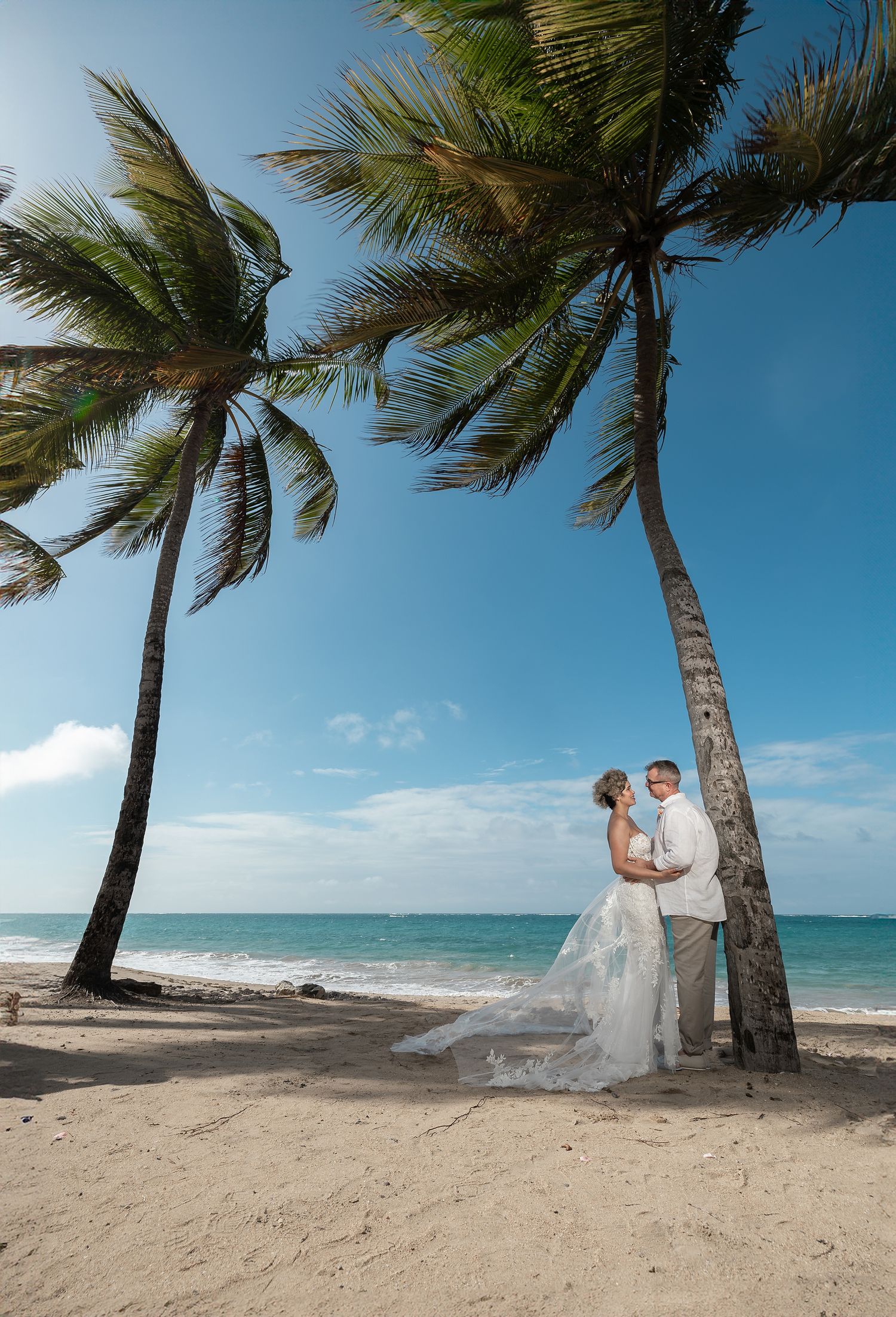 Couple portrait on tropical beach with palm trees — destination beach wedding photographer Puerto Rico Raymond Vega