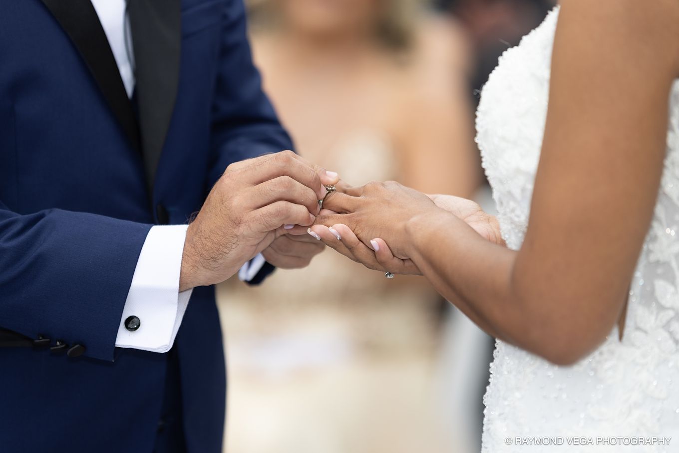 Groom placing a wedding ring on bride's finger during an outdoor wedding ceremony, close-up shot. Antiguo Casino Puerto Rico