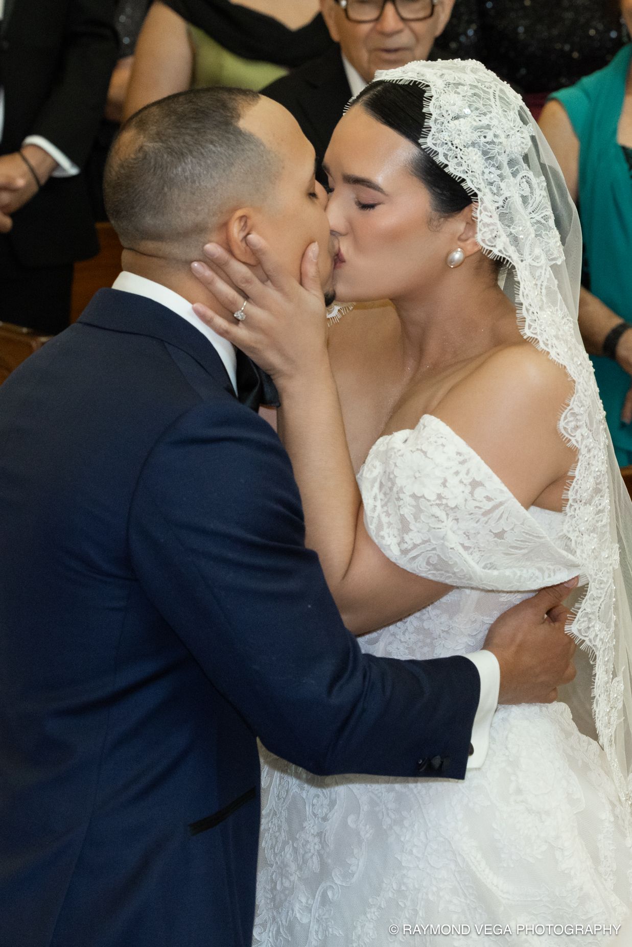 Bride and groom share their first kiss at the altar during a romantic church wedding ceremony.