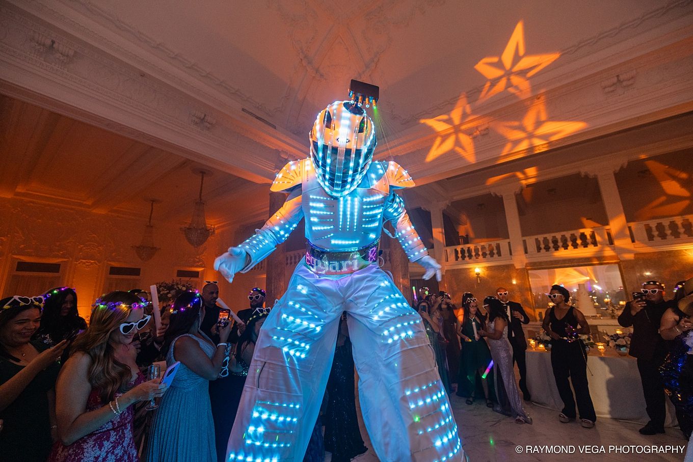 LED light-up stilt walker performer entertaining guests at an elegant wedding reception with star projections. SAK ENTRETAIMENT