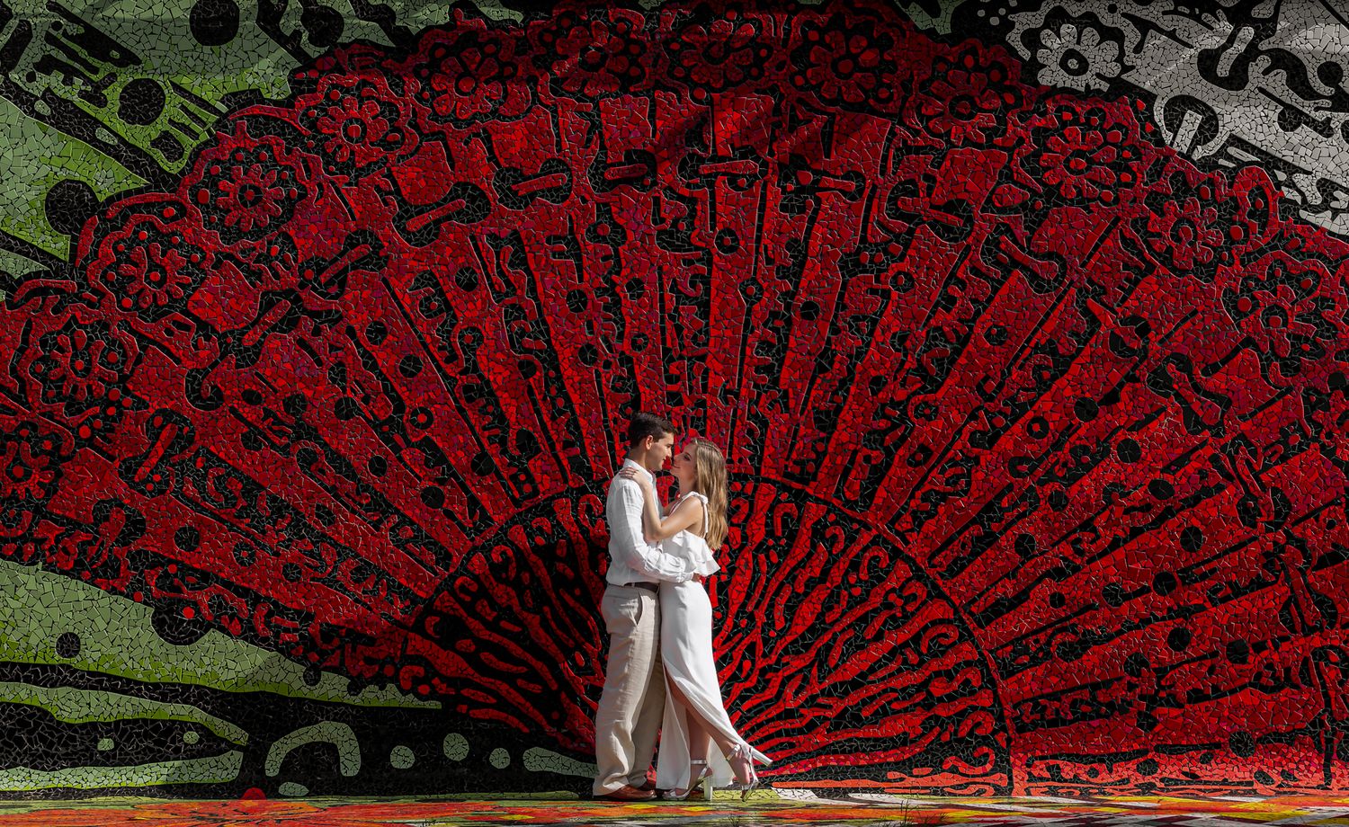 Bride and groom before giant red fan art installation — creative wedding photographer Puerto Rico Raymond Vega