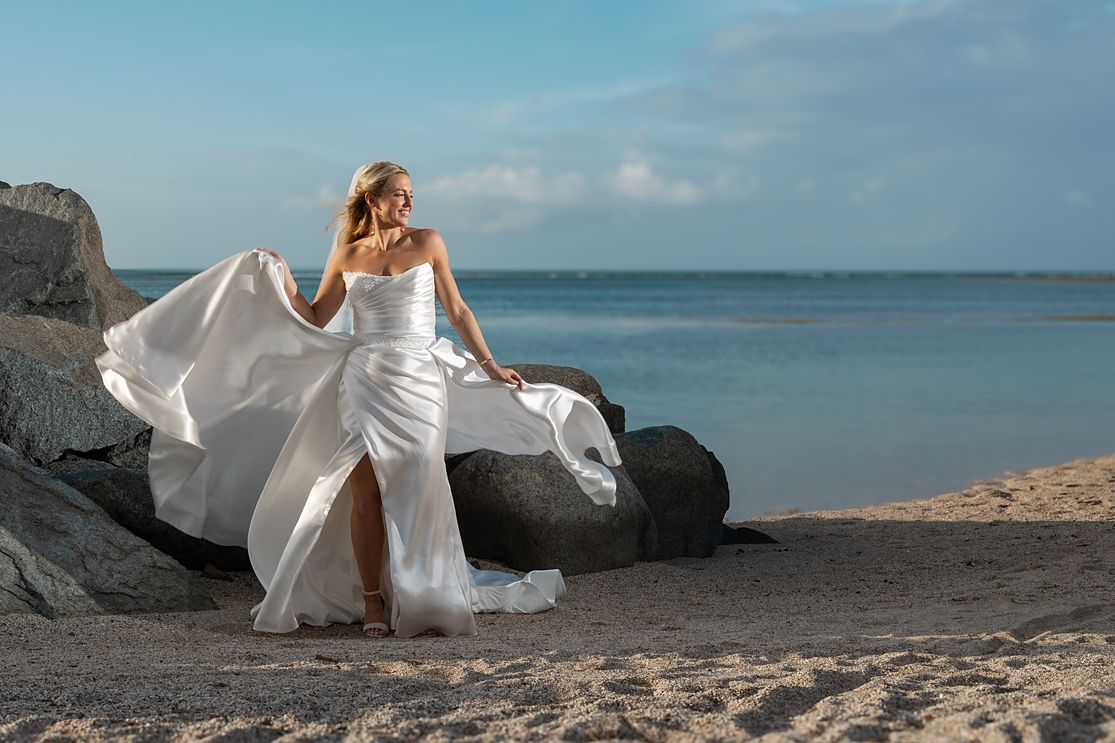 Bride in flowing gown on rocky beach Puerto Rico — destination wedding photographer Raymond Vega