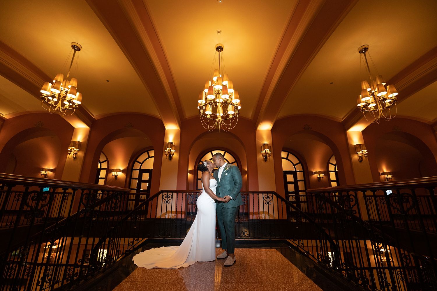 Bride and groom under golden arches at Condado Vanderbilt Hotel San Juan Puerto Rico — wedding photographer Raymond Vega