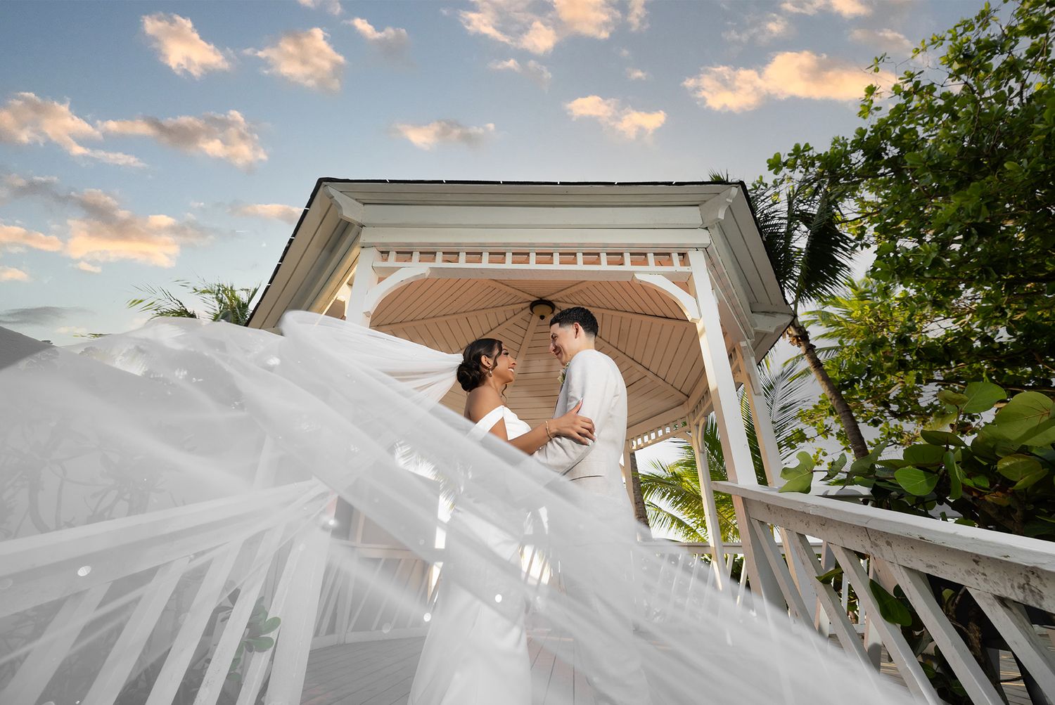 Bride and groom in white gazebo with dramatic veil at Royal Sonesta Puerto Rico — destination wedding photographer Puerto Rico Raymond Vega