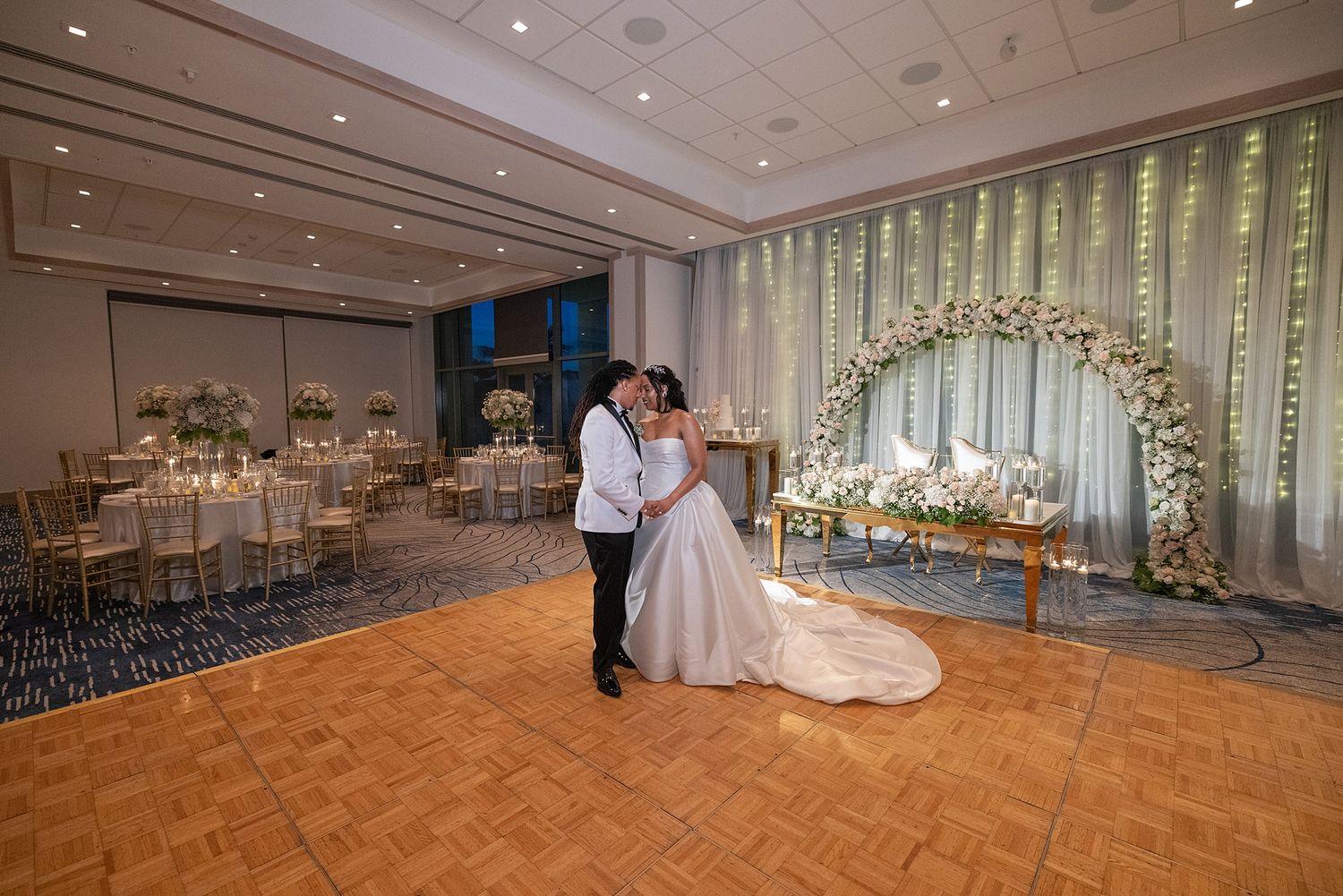 Bride and groom share first dance in elegant wedding reception hall with floral arch and candlelit tables.Hotel La Concha Puerto Rico