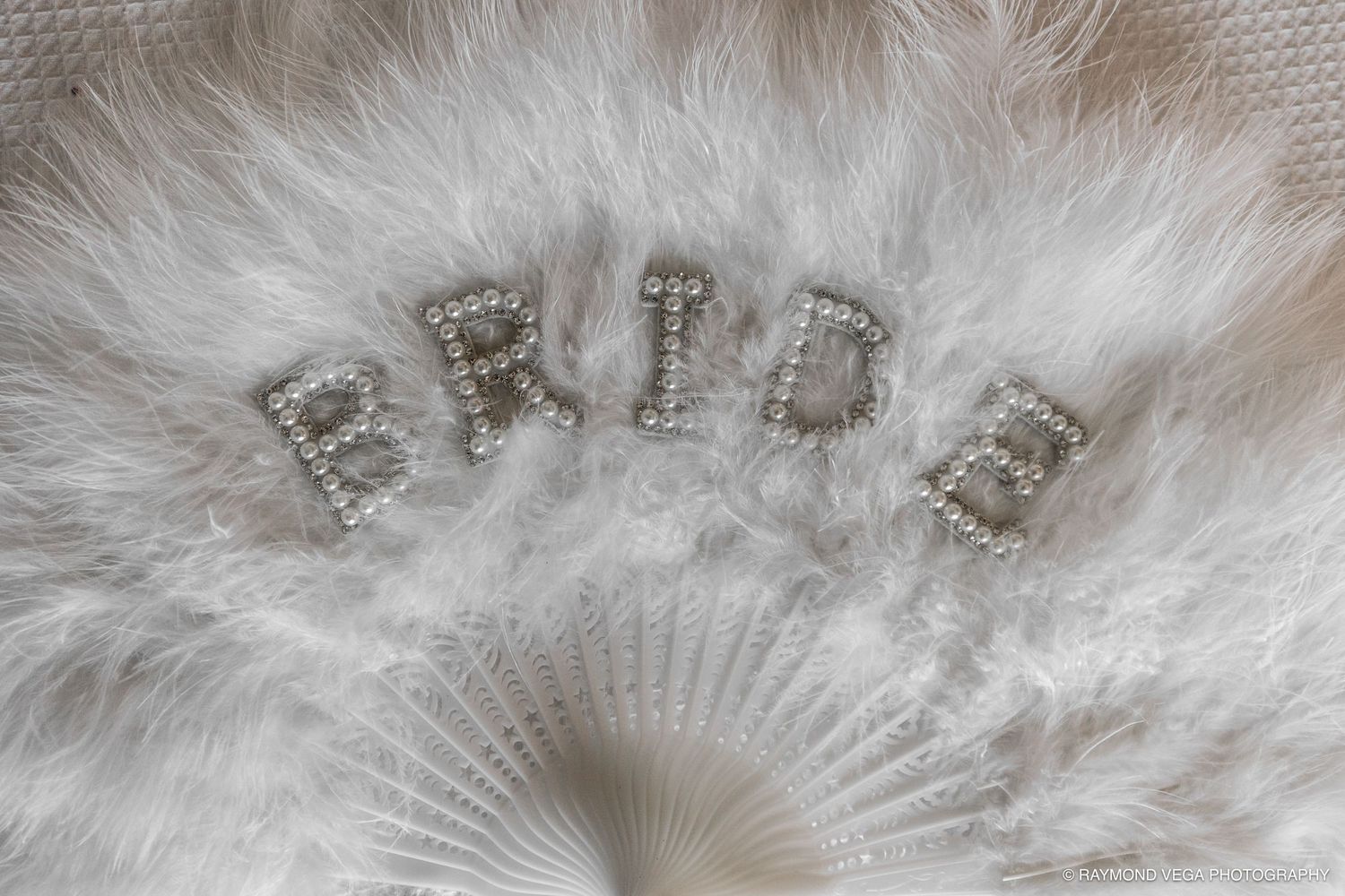 White feather fan with rhinestone BRIDE letters, perfect bridal accessory for weddings and bachelorette parties.