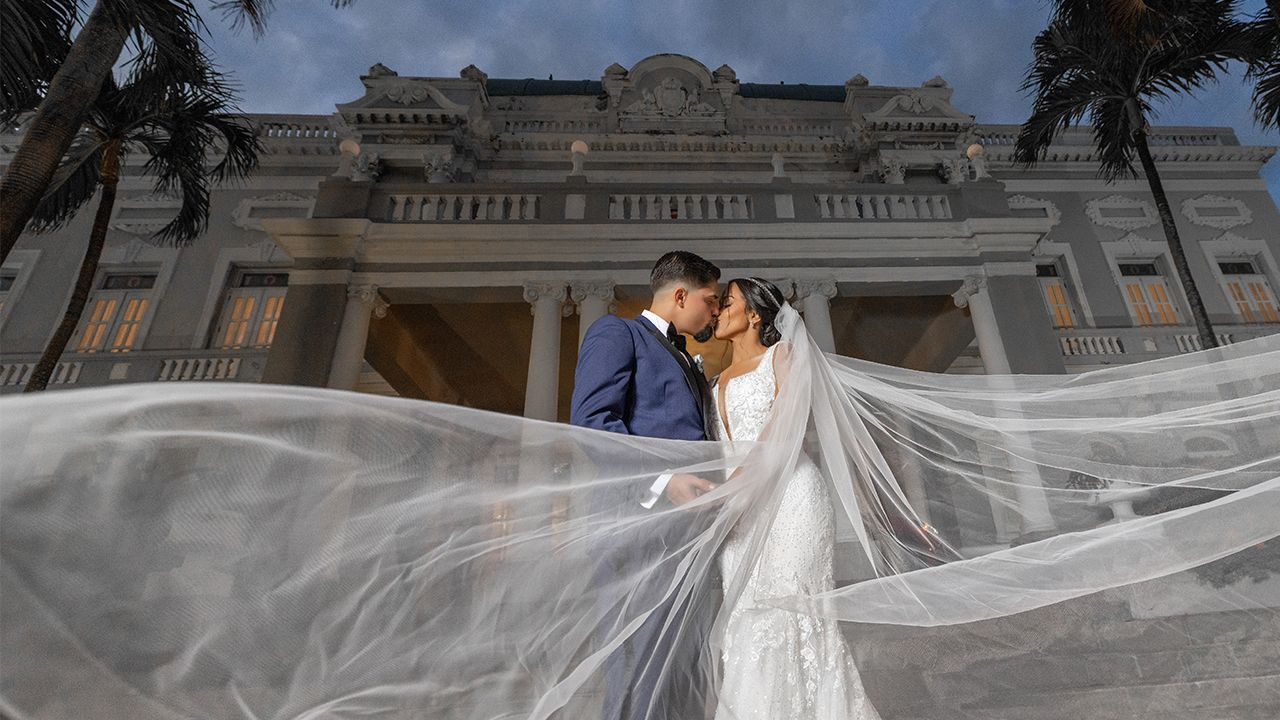 Bride and groom kiss with dramatic flowing veil at Antiguo Casino Puerto Rico — Raymond Vega