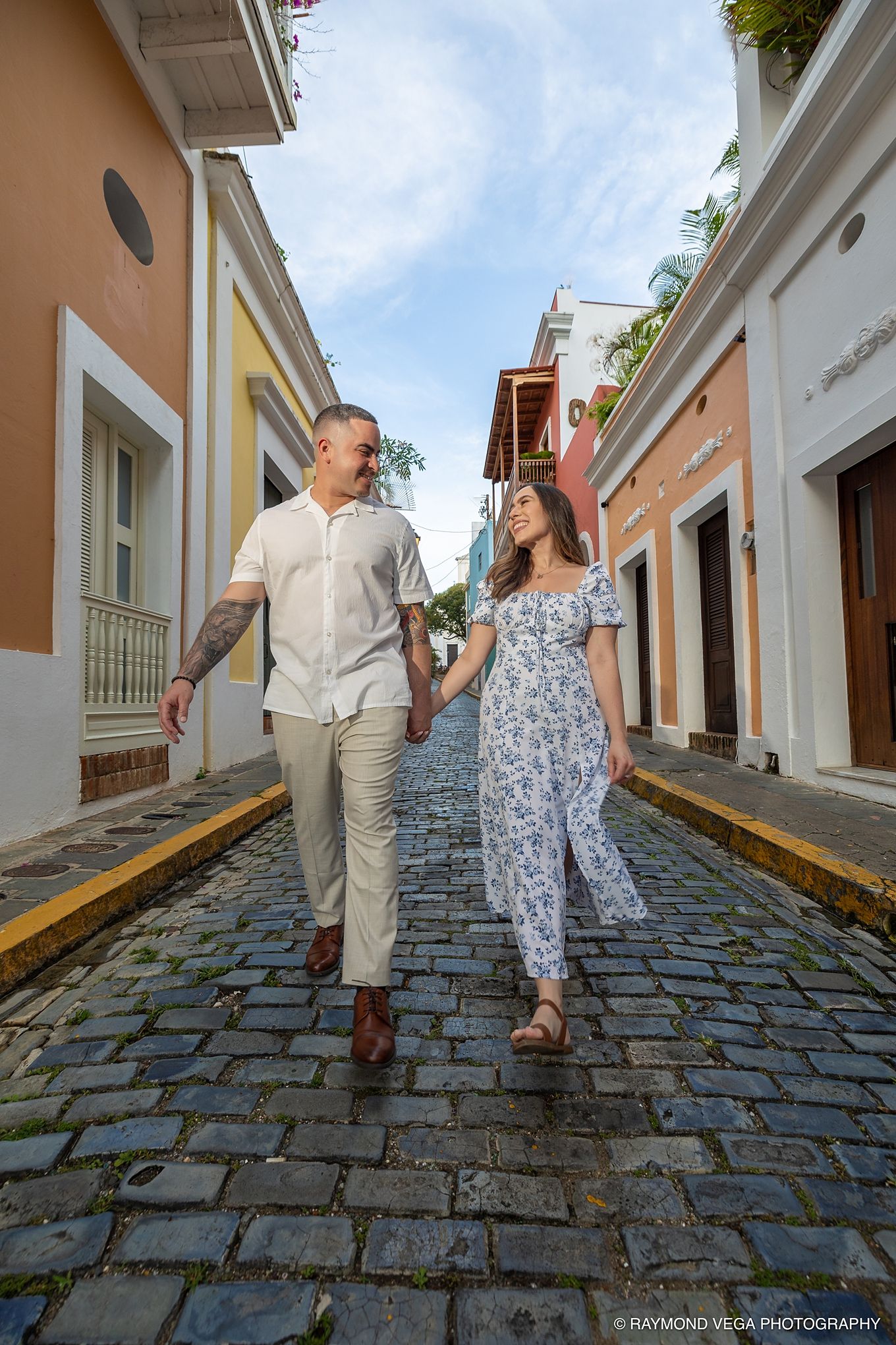 Couple holding hands walking on cobblestone street in colorful Old San Juan, Puerto Rico. - Love Story