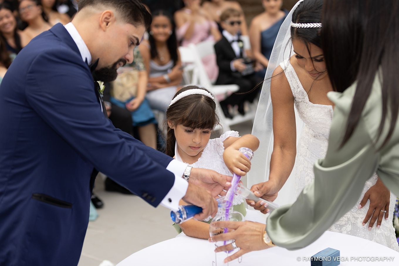 Bride and groom with flower girl pouring sand during a unity ceremony at an outdoor wedding. Antiguo Casino Puerto Rico