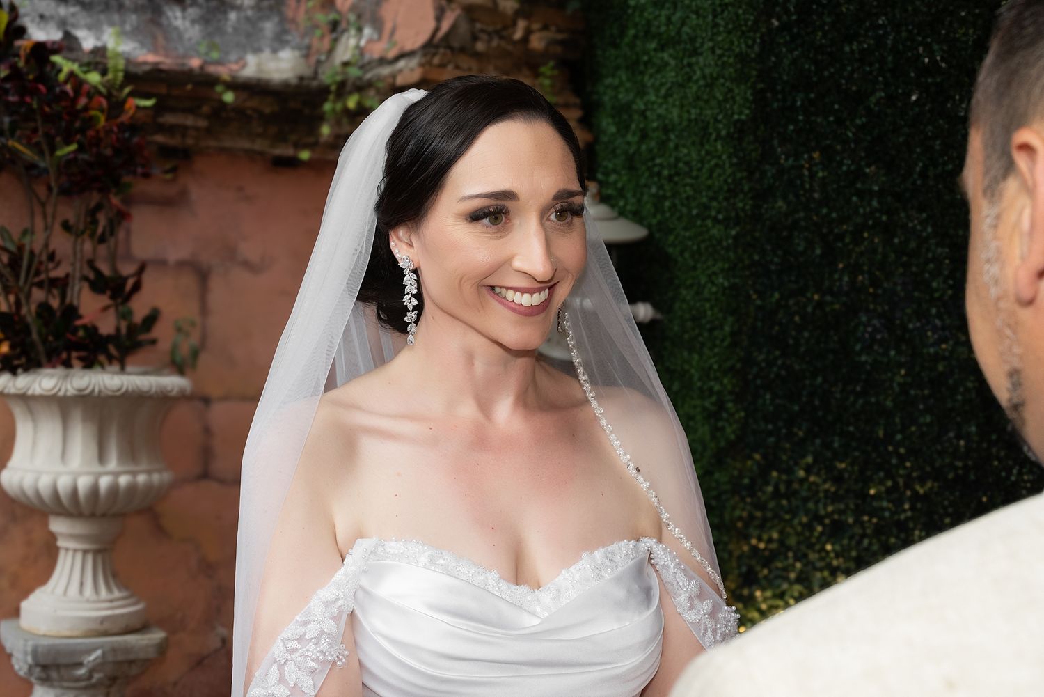 Smiling bride in white strapless gown and veil at outdoor wedding ceremony. Gallery Inn Puerto Rico