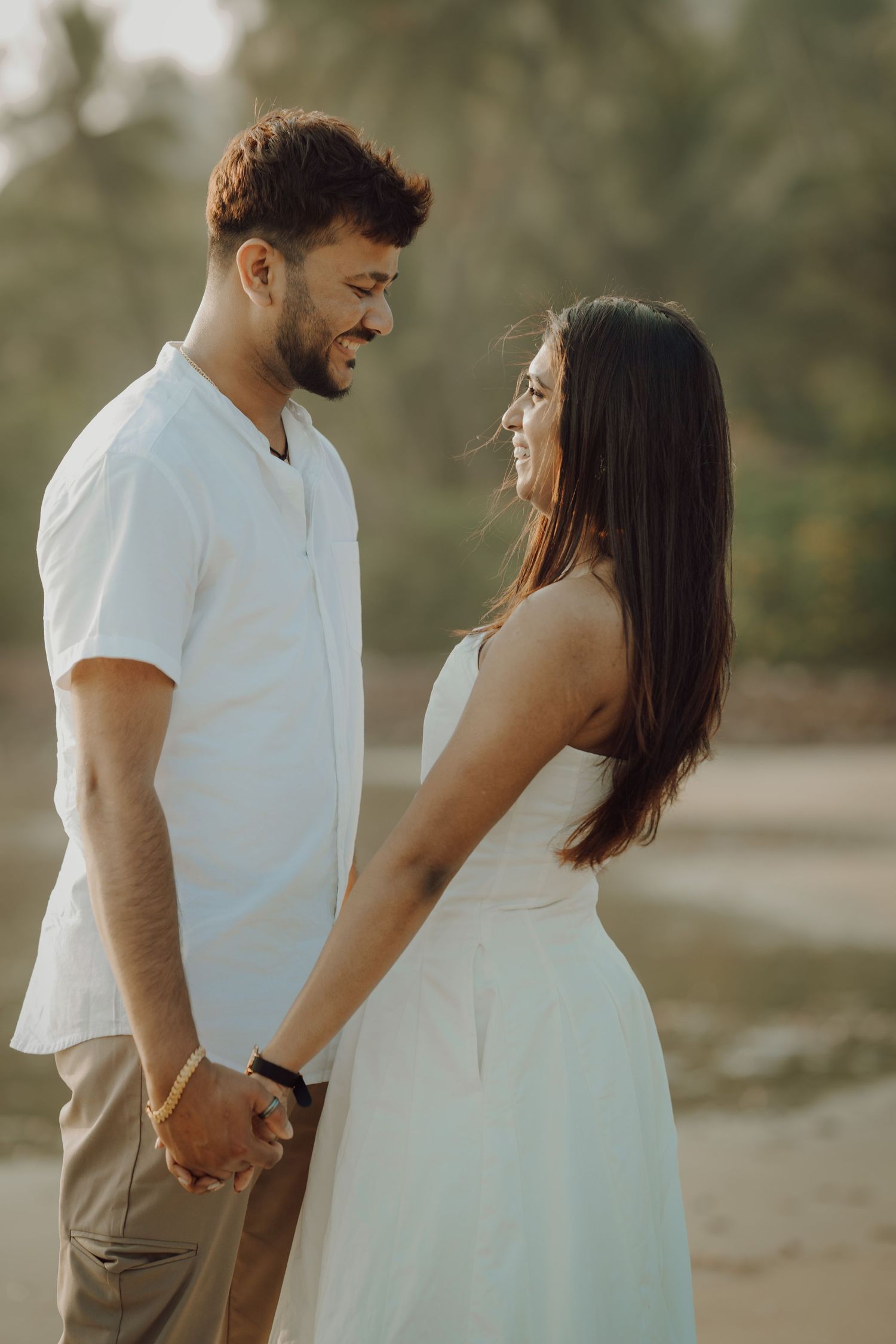 A romantic couple shares tender moments in a series of outdoor photos wearing white and beige outfits.