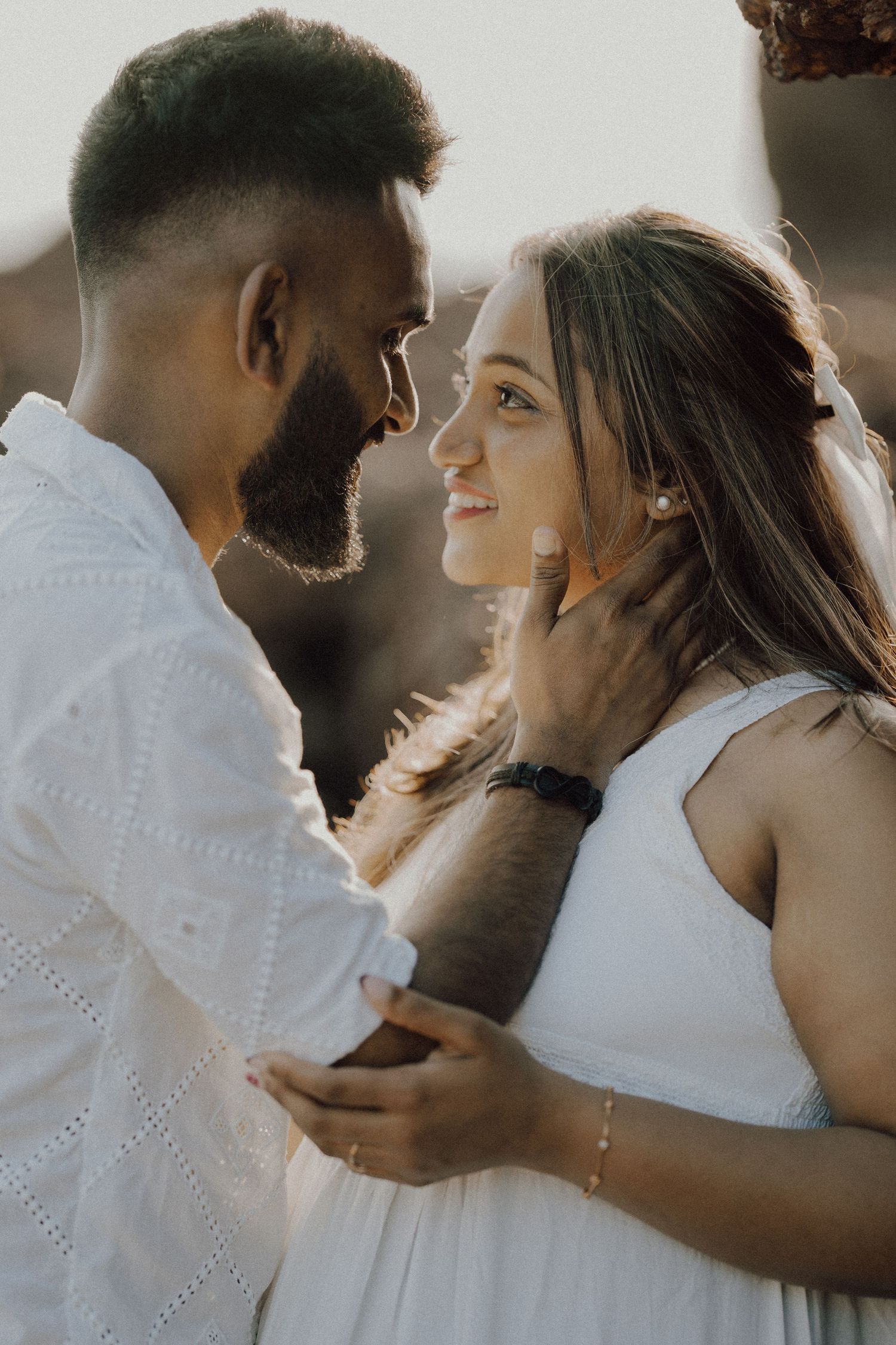 Romantic couple in white outfits share intimate moments in a progressive series of four portrait photos.