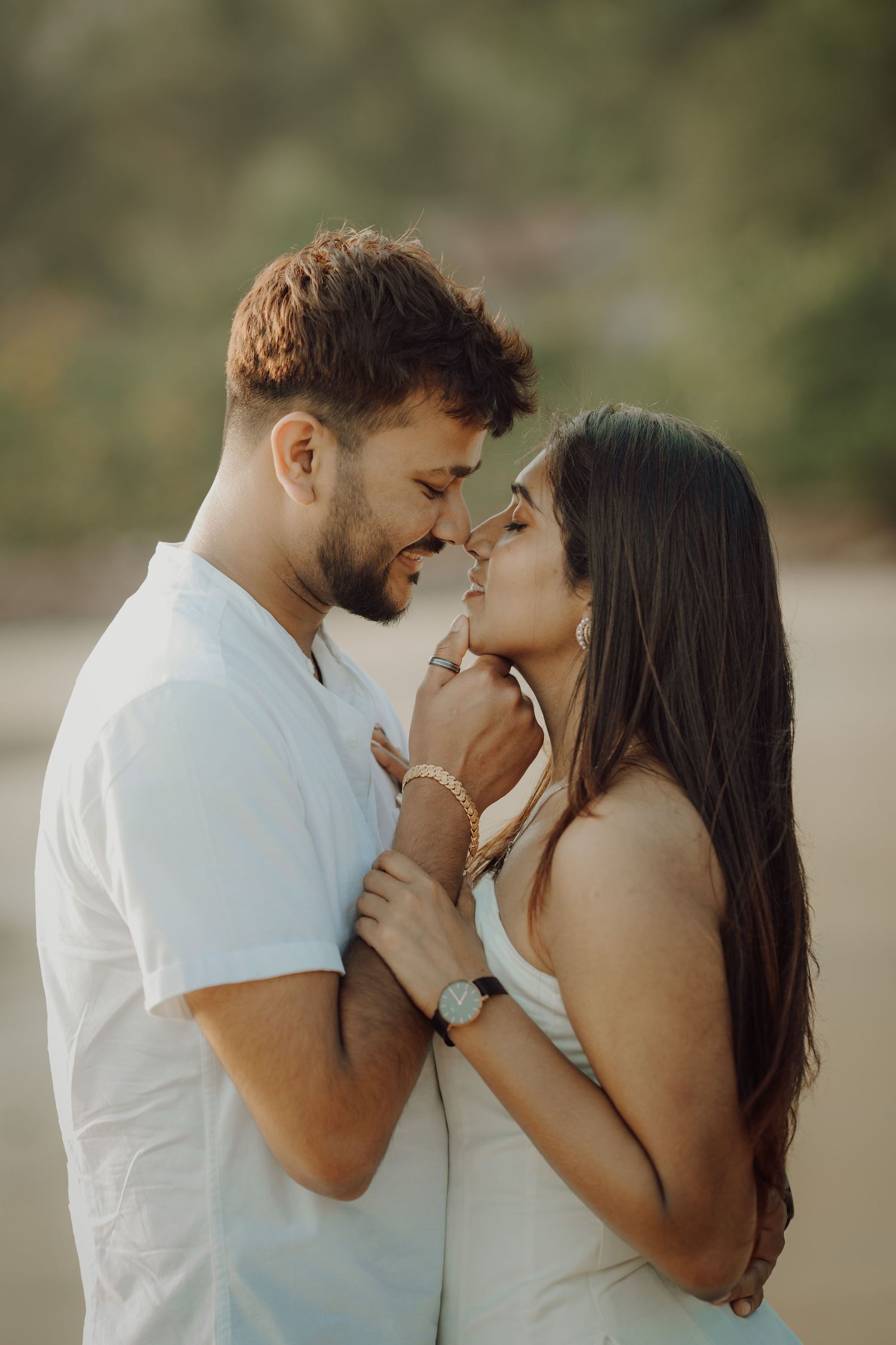 A romantic couple in white outfits share intimate moments in a series of tender outdoor portrait photographs.
