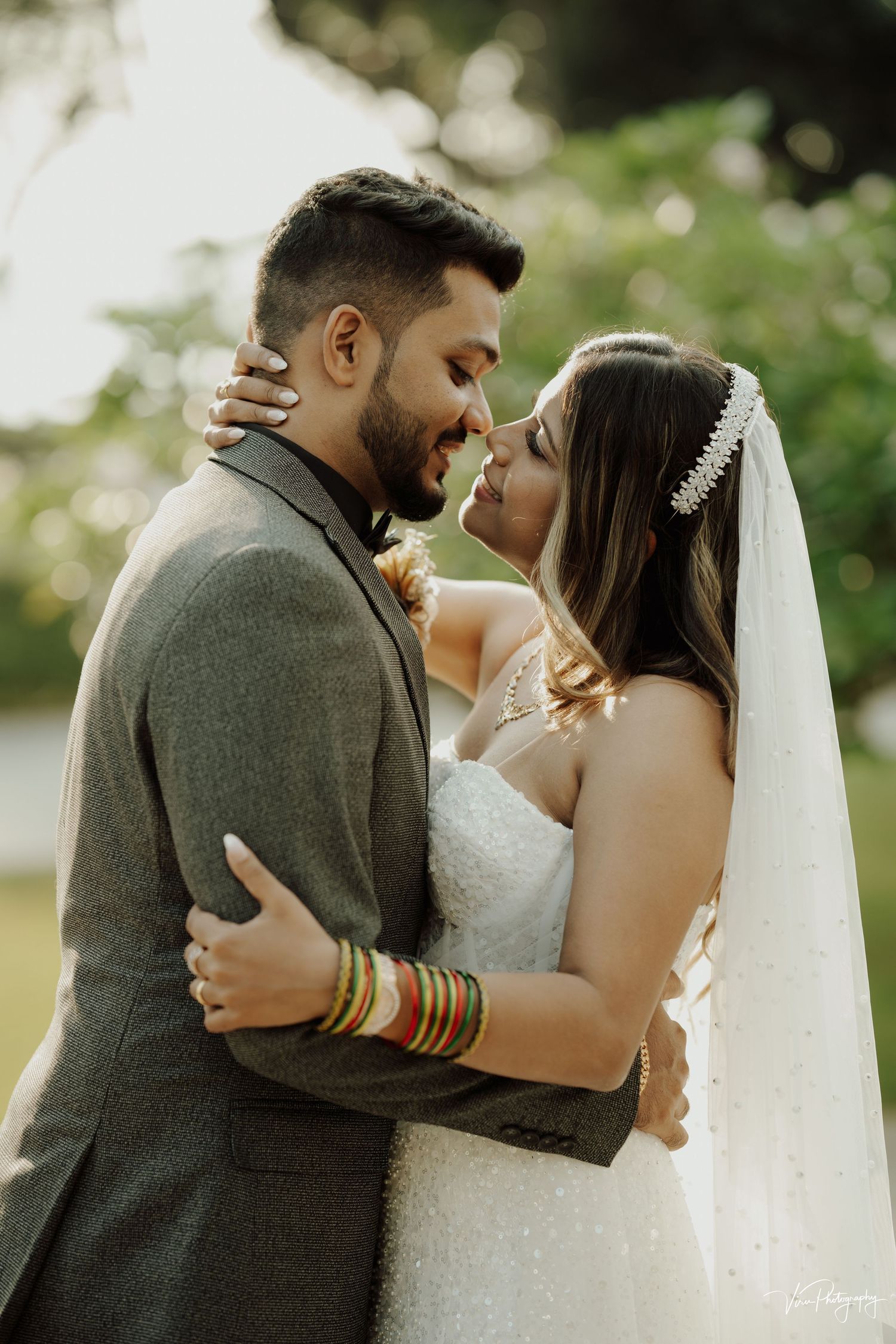 A romantic outdoor wedding portrait showing the newlywed couple embracing during golden hour.