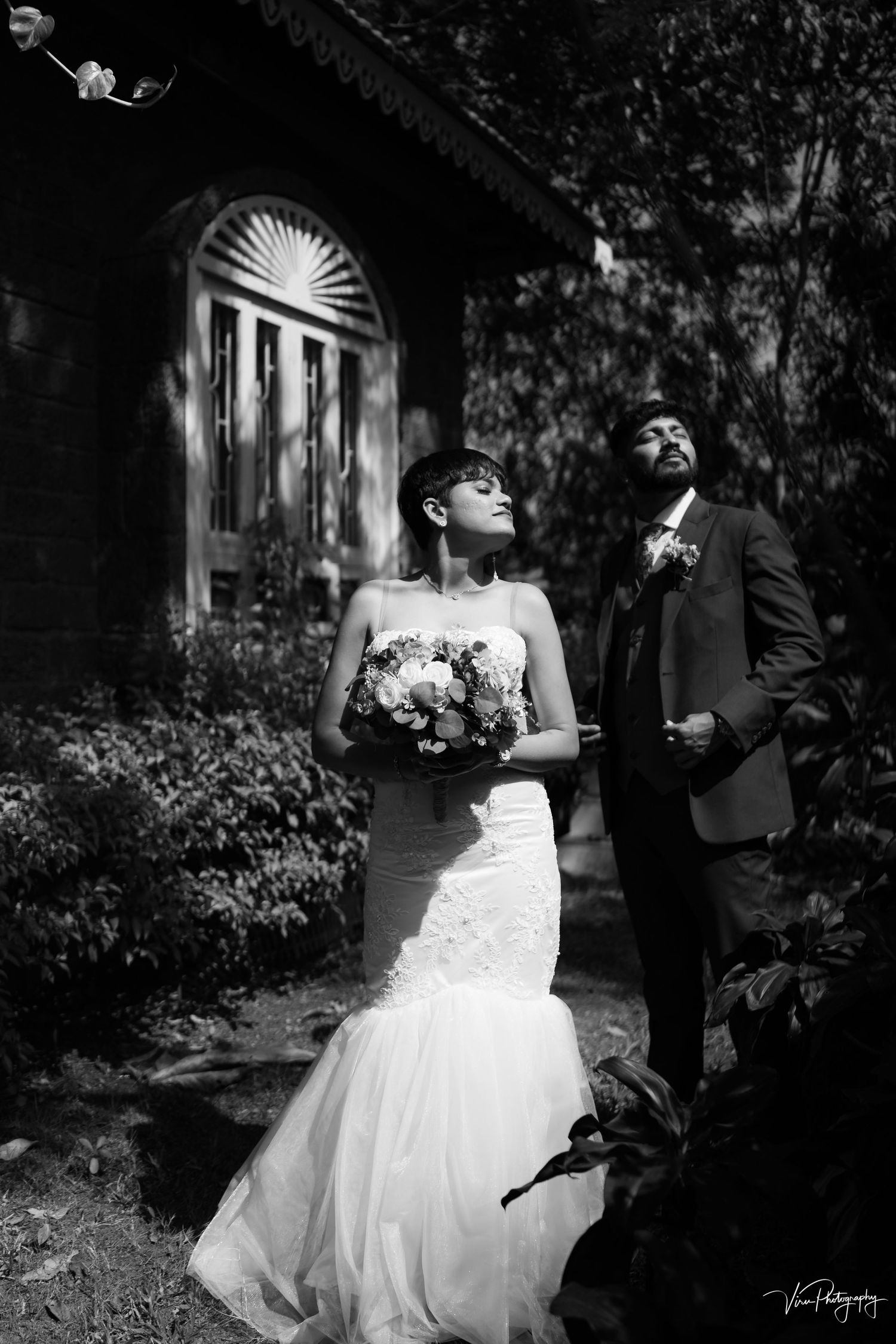 Black and white romantic wedding portraits of bride and groom sharing intimate moments in a garden setting.