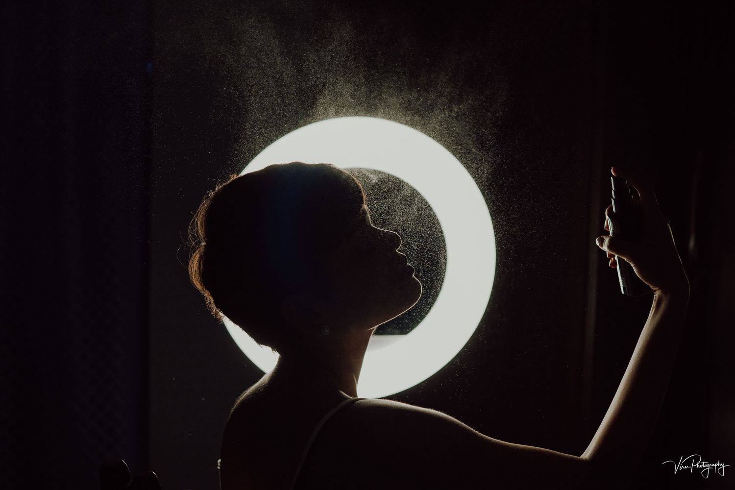 Artistic silhouette of a crescent moon shape against a dark background creating dramatic lighting effect.