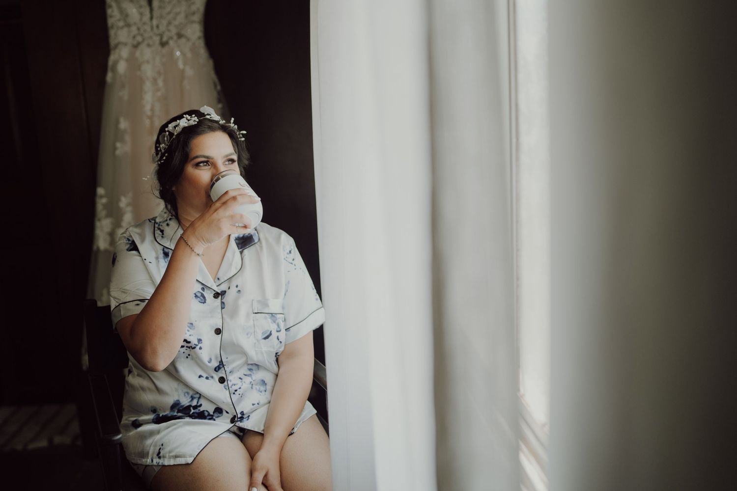 A quiet moment by the window during wedding preparations.