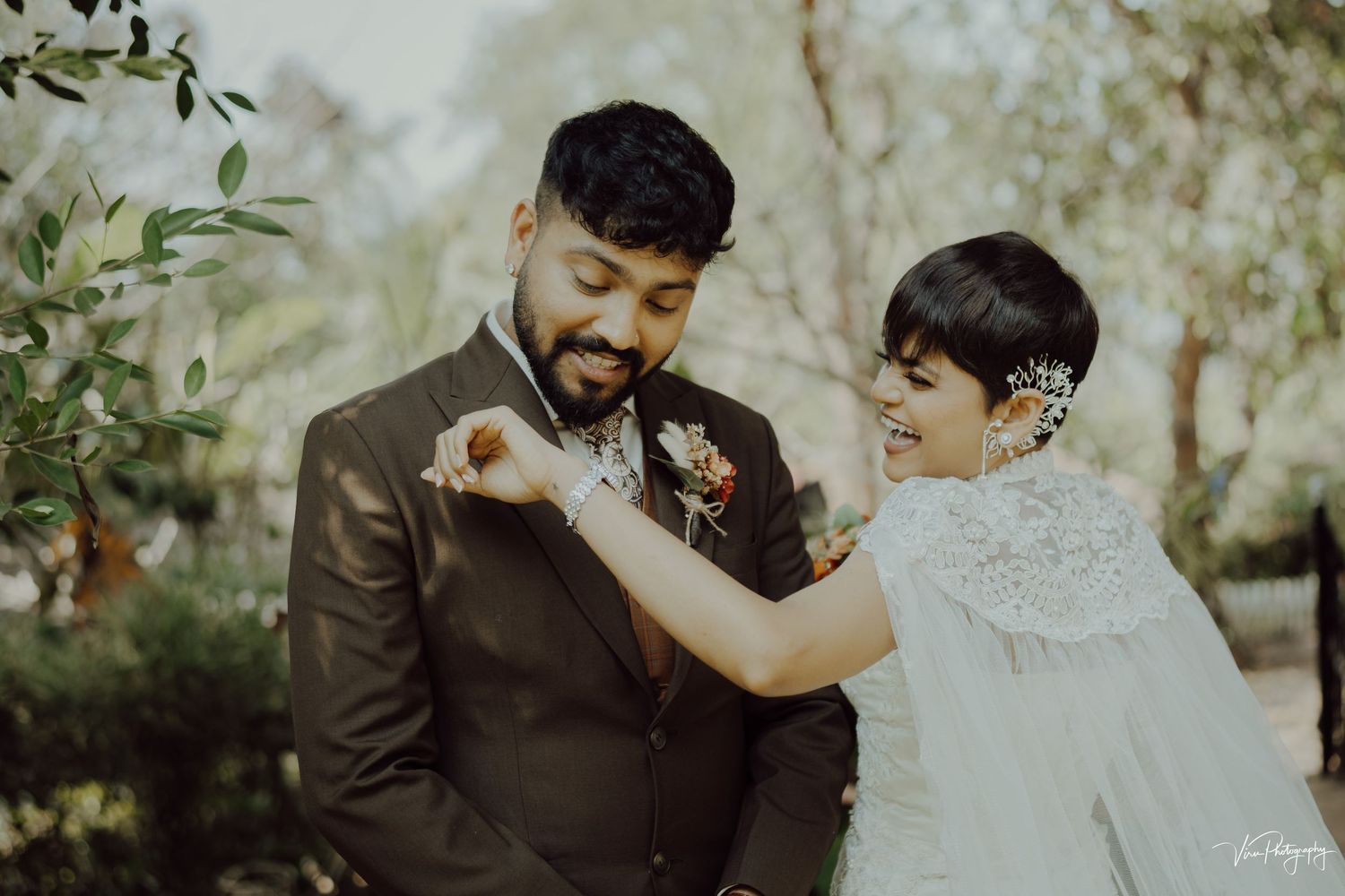 A couple shares a tender moment during their wedding day in a natural outdoor setting.