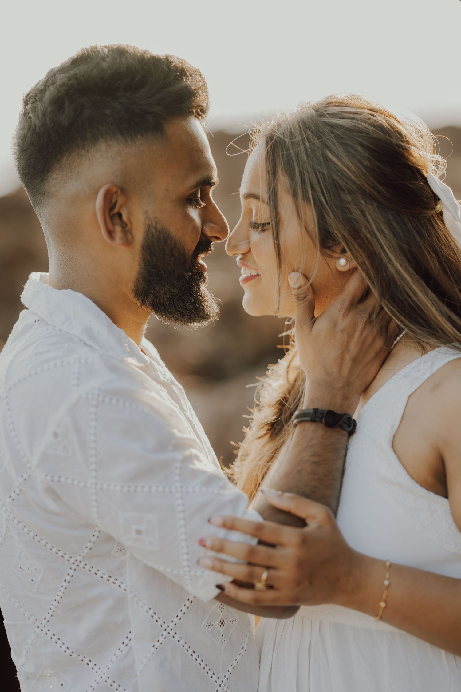 A romantic couple in white outfits sharing intimate moments in a series of connected photos at sunset.