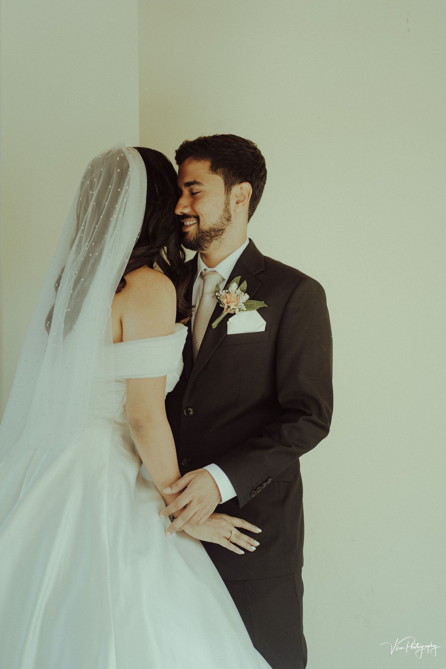 A tender moment between newlyweds in an elegant wedding portrait with soft vintage lighting.