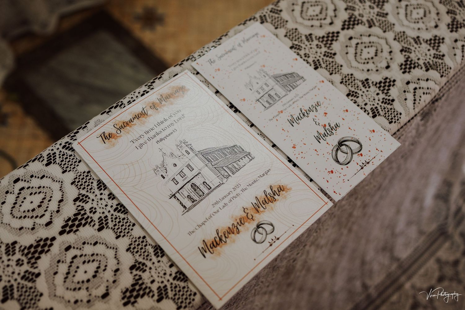 Custom wedding invitation with hand-drawn illustrations of a church on delicate lace backdrop.