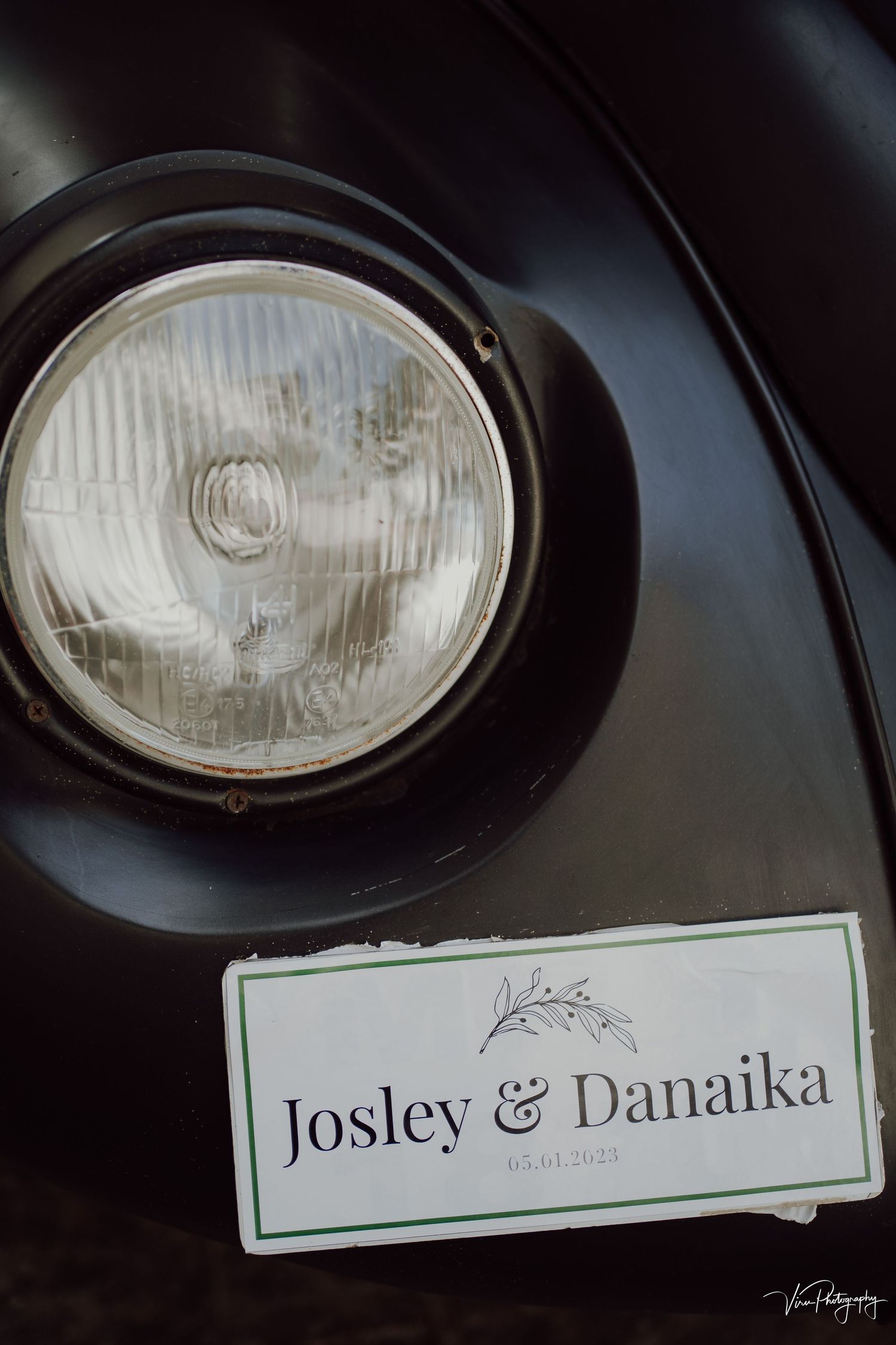 Classic car headlight detail with a nameplate reading 