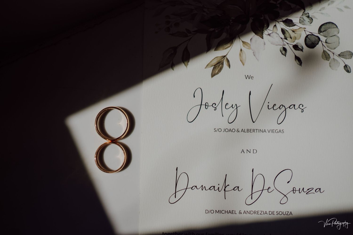 Wedding invitation detail shot showing number 8 and elegant handwritten names against a white background with floral elements.