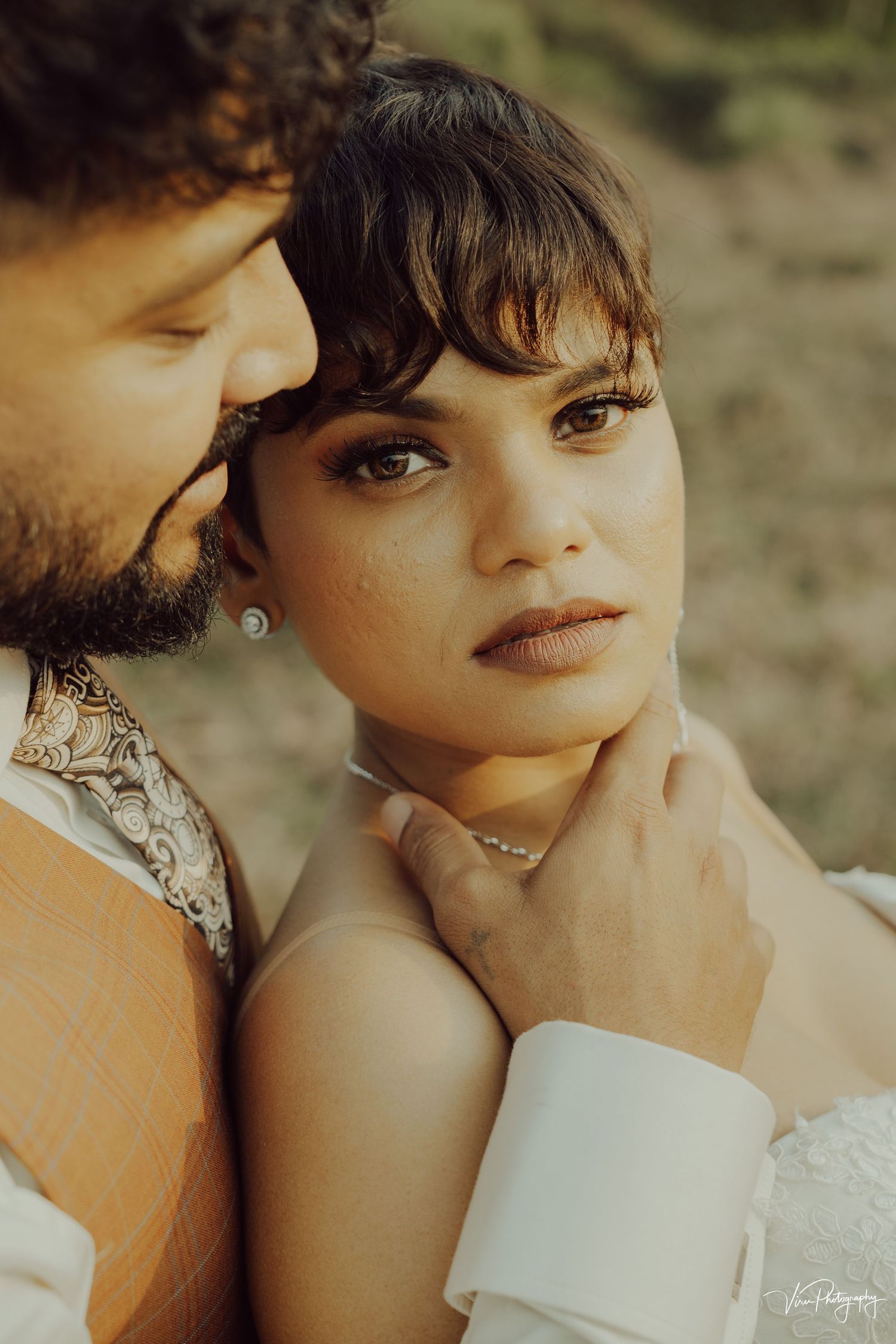 Romantic couple in warm golden light sharing an intimate moment during outdoor portrait session.