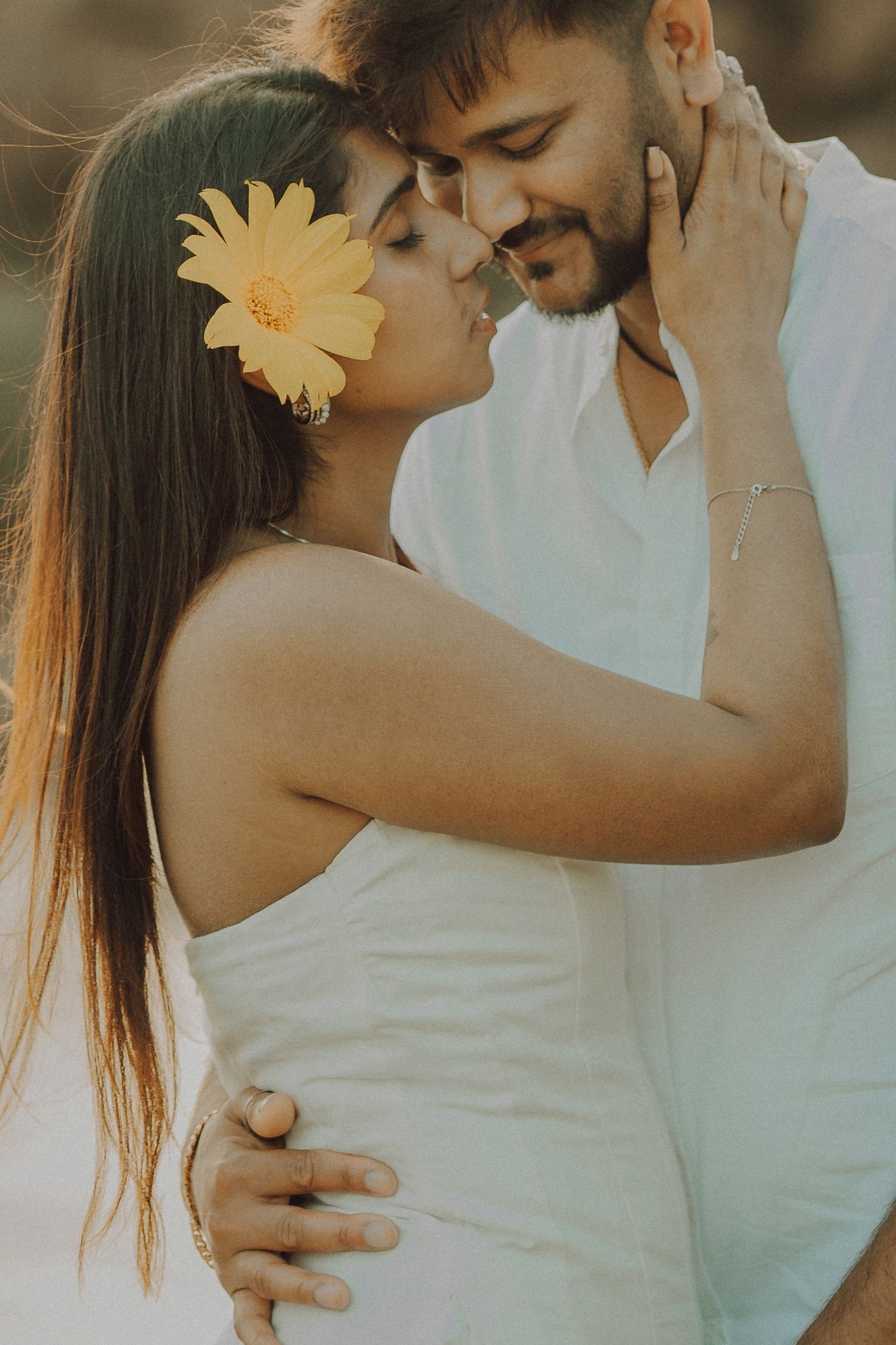 A romantic couple in white outfits embrace tenderly in a series of intimate outdoor photos with soft lighting.