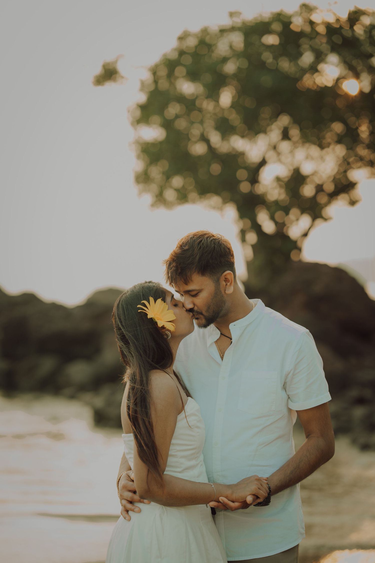 A romantic couple shares tender moments in a series of sunset photos with warm golden lighting and natural outdoor scenery.