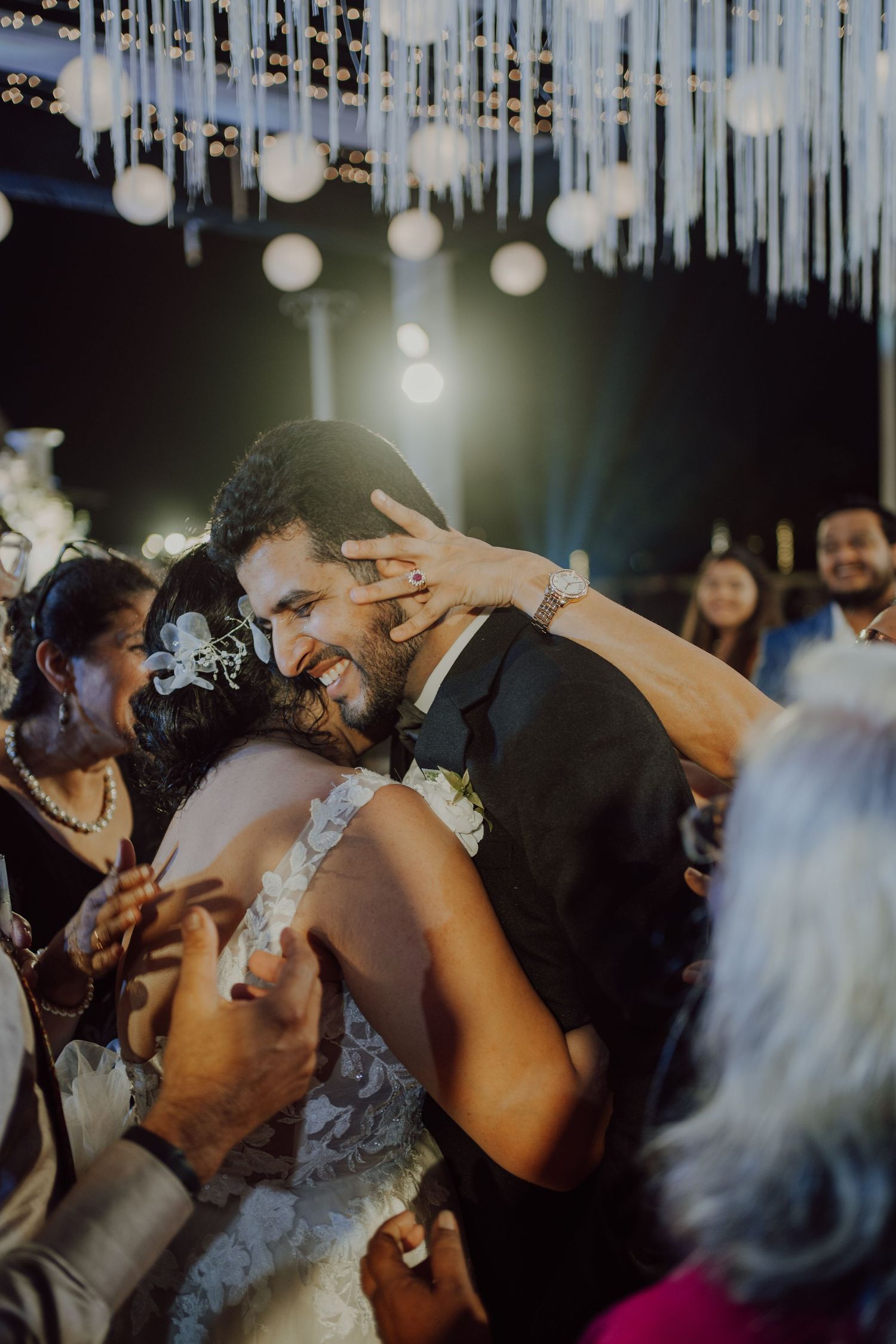 Intimate dance moment captured under twinkling lights at wedding reception.
