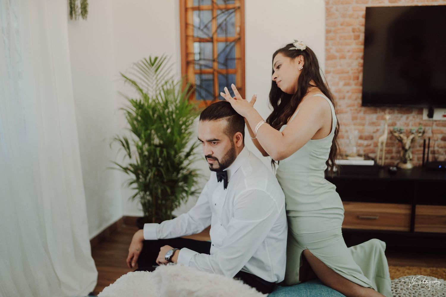 A massage therapy session in progress at a home spa with indoor plants and brick wall decor.
