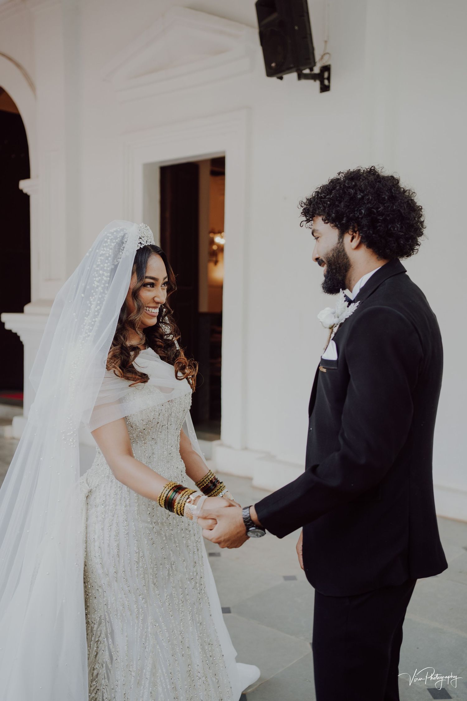 A beautiful wedding moment shows a couple in traditional attire, with the bride in a white lace gown and long veil.