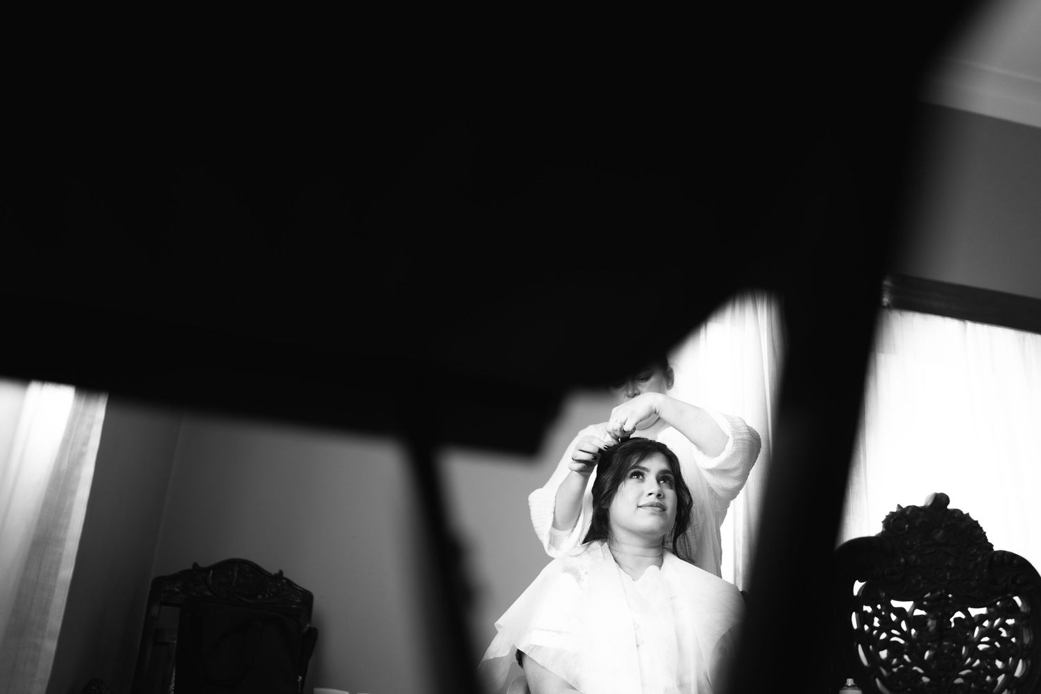 A dramatic black and white shot capturing wedding morning preparation with light and shadow effects.