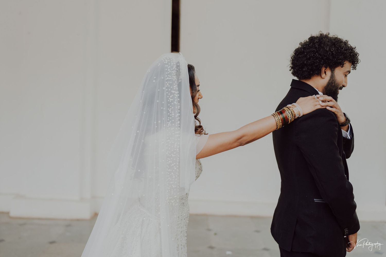 A bride and groom share a romantic first look moment before their wedding ceremony.