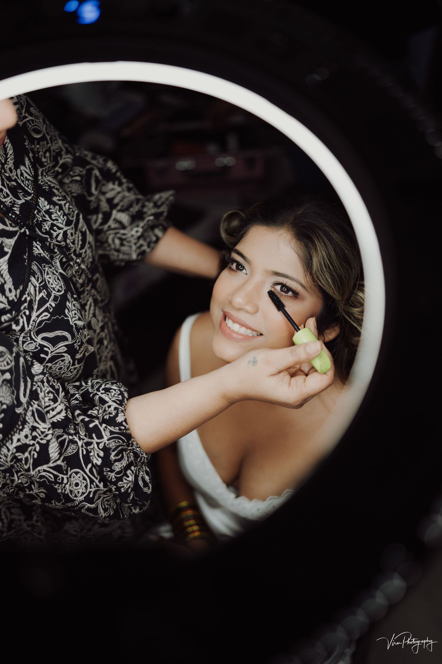 Creative circular mirror reflection showing preparations with white dress and floral decorative elements.