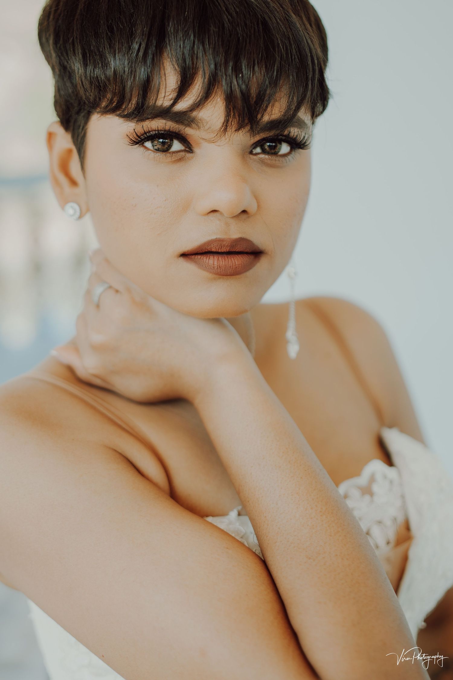 Elegant close-up portraits showing radiant makeup artistry with warm neutral tones and wispy bangs against a light backdrop.