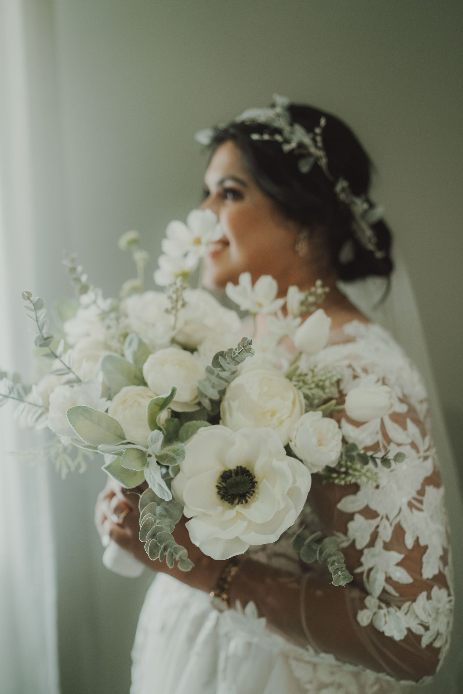A stunning bridal portrait featuring a white floral bouquet and delicate crystal headpiece.