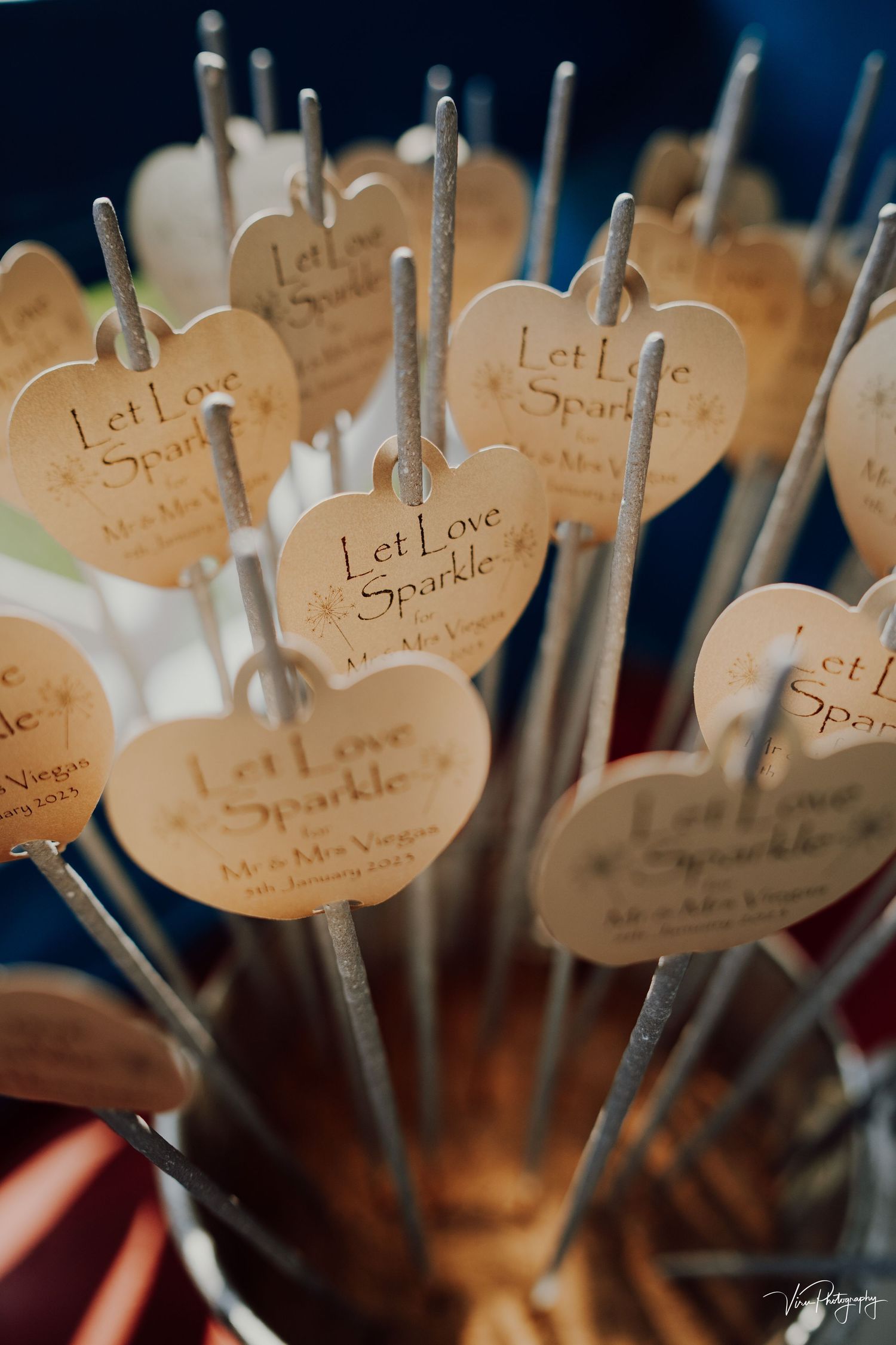 Wedding sparklers with kraft paper heart tags reading 'Let Love Sparkle' arranged in a decorative display.