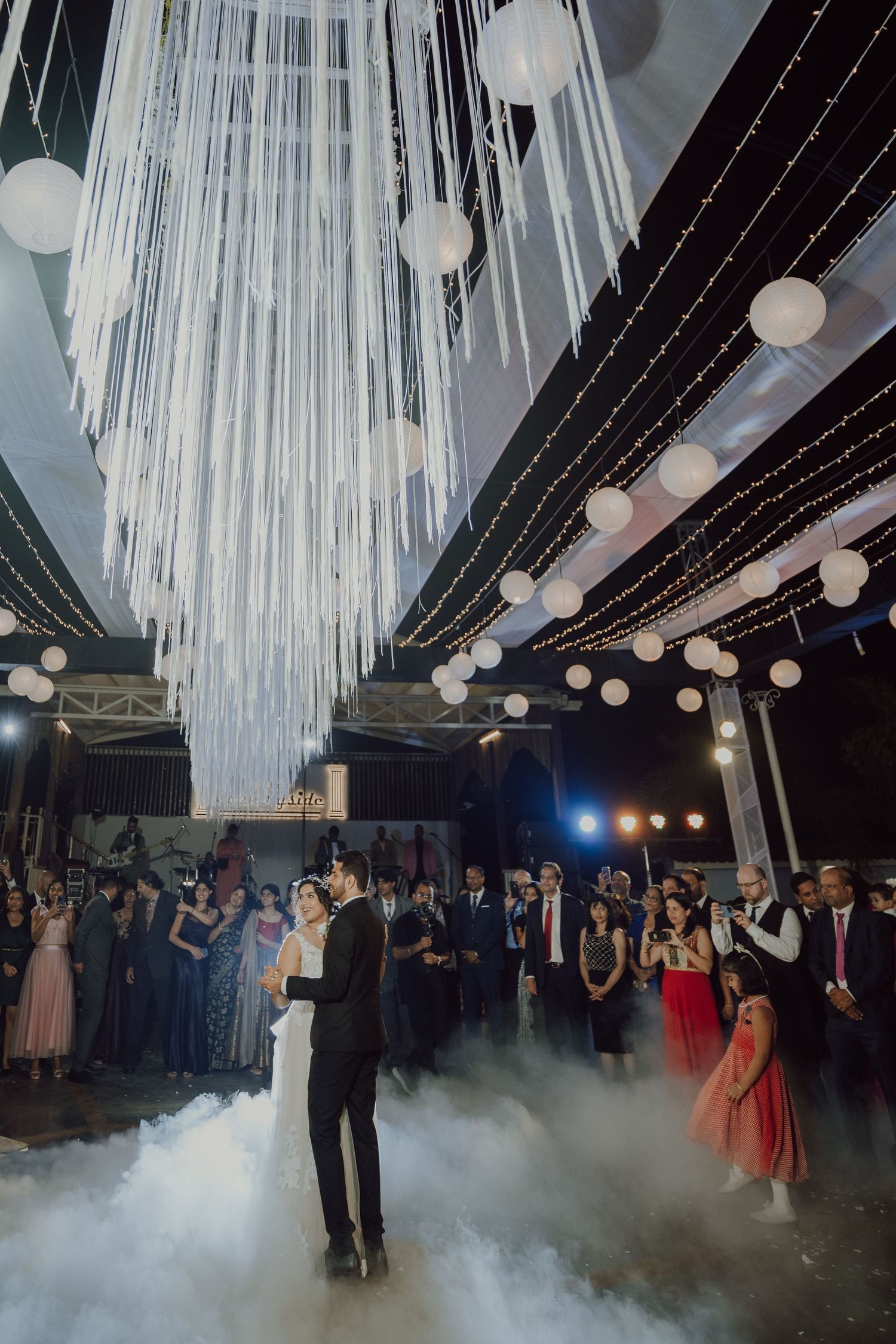 Wedding reception venue with dramatic white fabric ceiling draping and fog effects on dance floor.