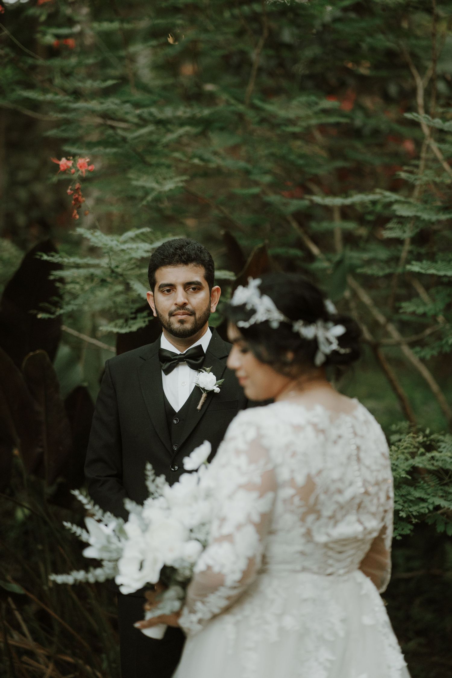An artistic wedding portrait captured in a moody forest setting.