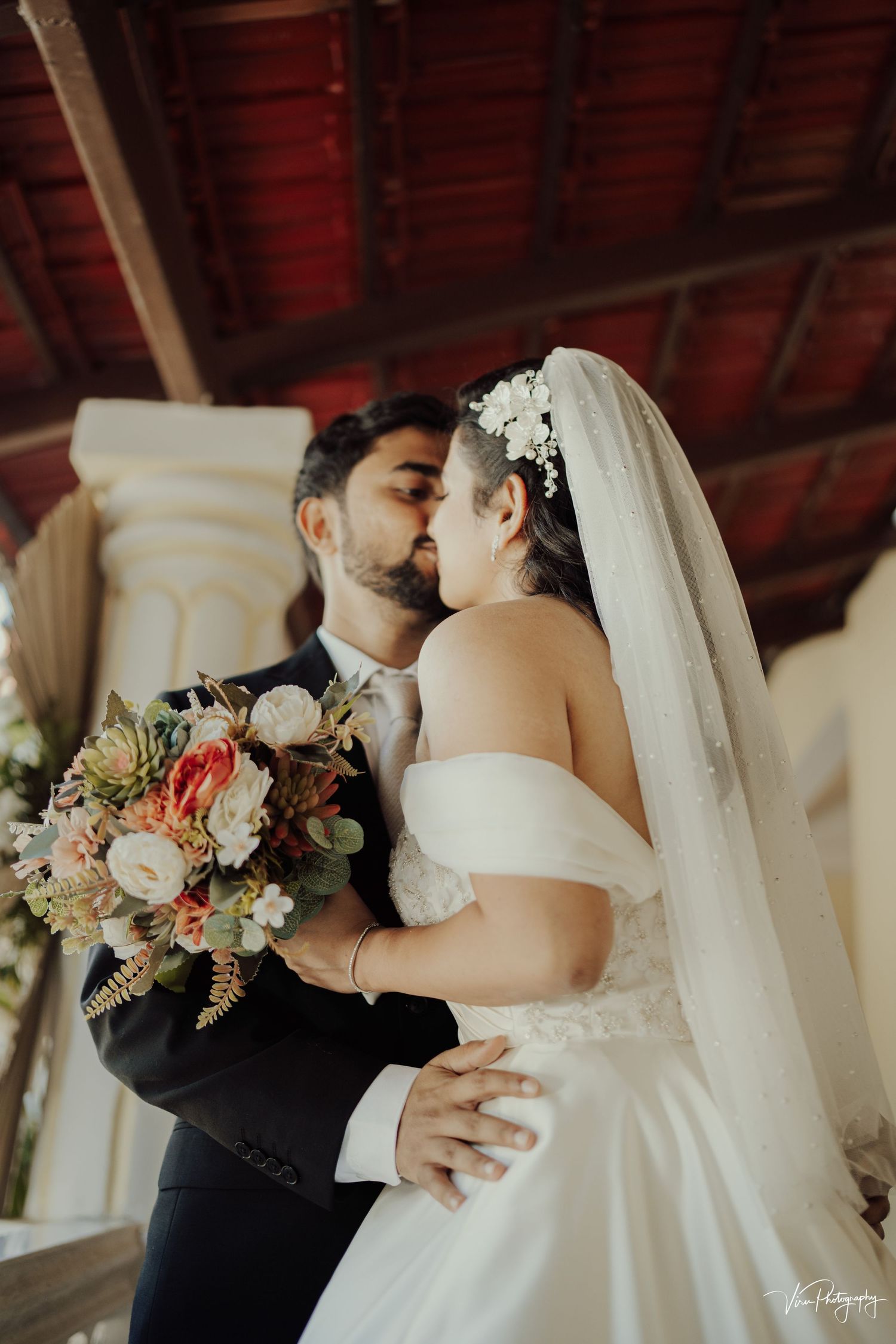 A romantic wedding moment captured with a beautiful bridal bouquet featuring blush and white florals and a flowing veil.