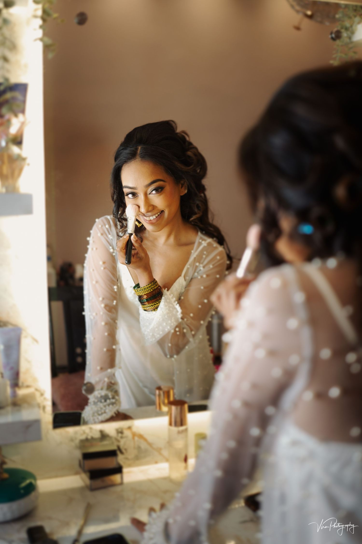 Reflection in mirror shows intricate lace long-sleeved wedding dress with delicate polka dot details.