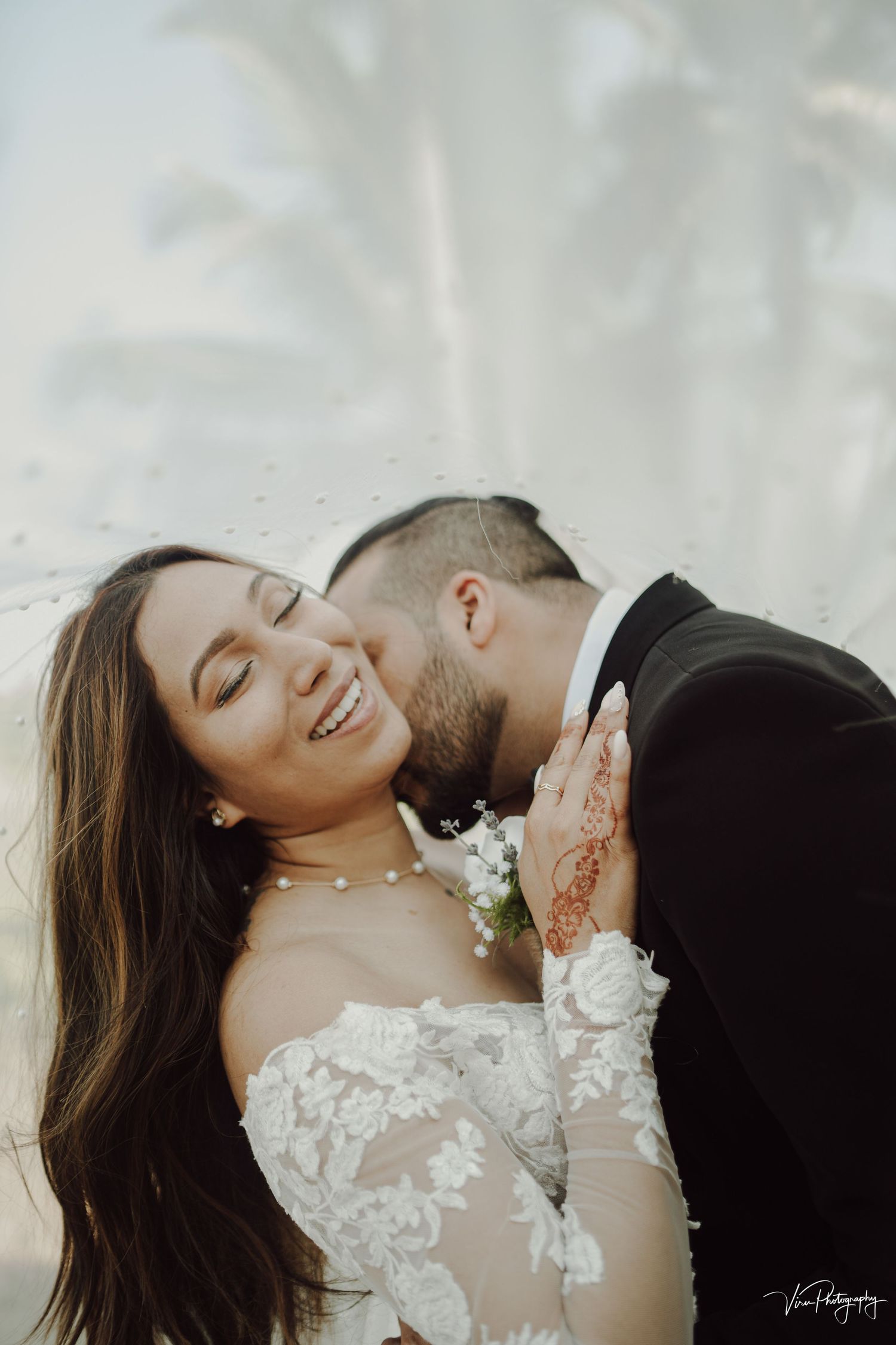 A bride and groom share an intimate moment during their outdoor wedding photoshoot.