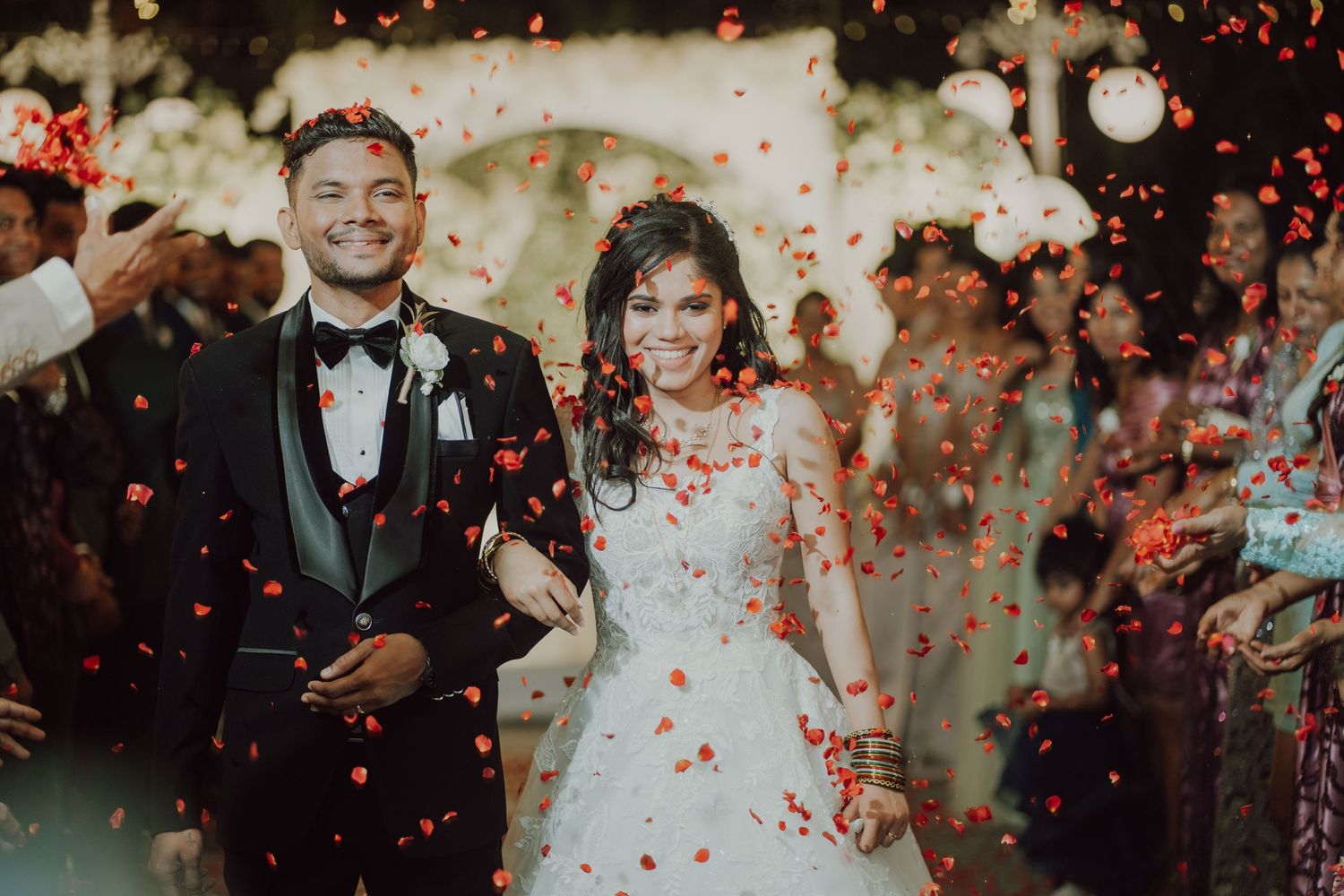 Red confetti showers down on newlyweds during their wedding celebration.