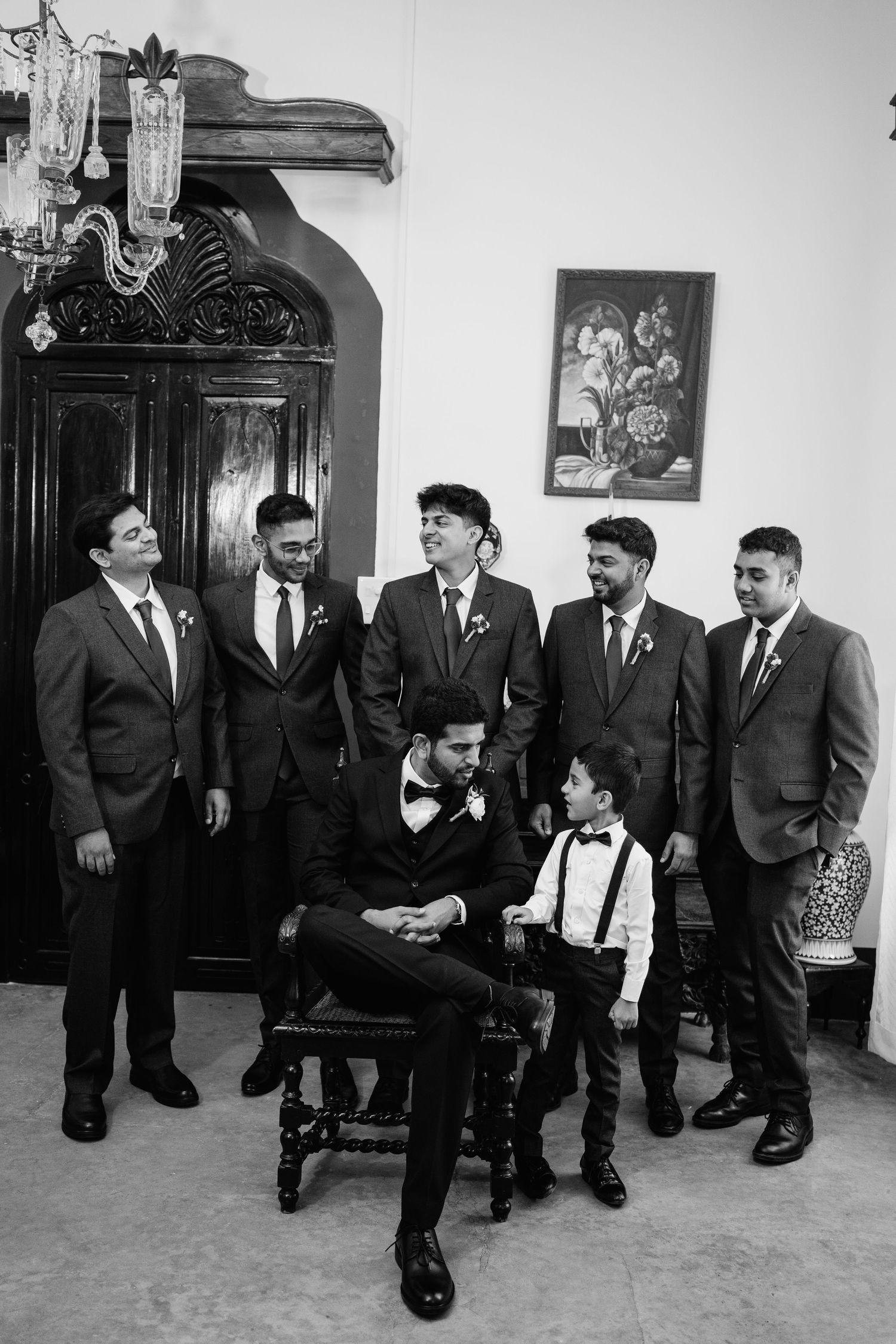 Wedding party members in suits posing for a classic black and white photograph.