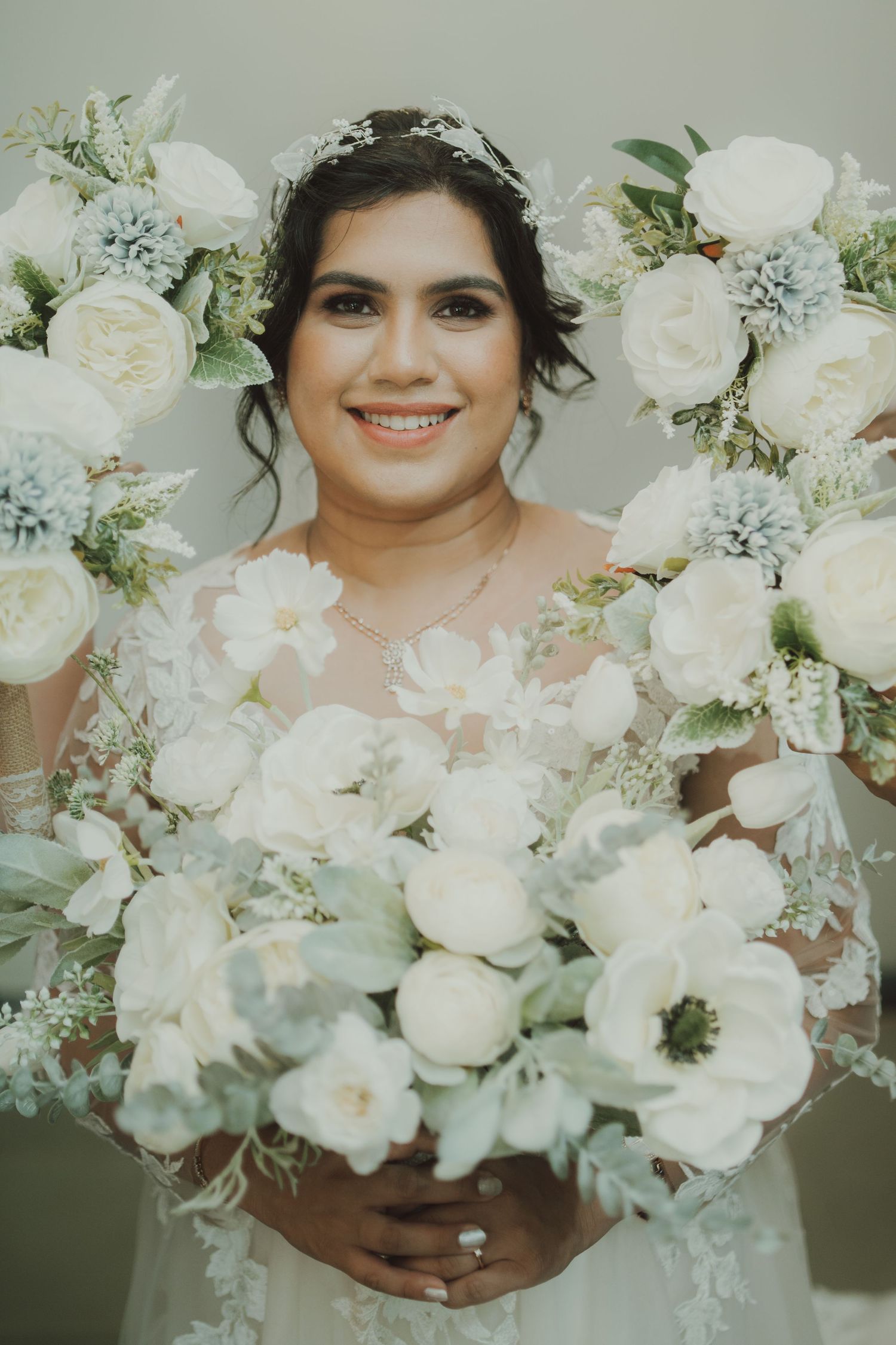 Beautiful bridal bouquet with white roses and delicate greenery in a romantic setting.